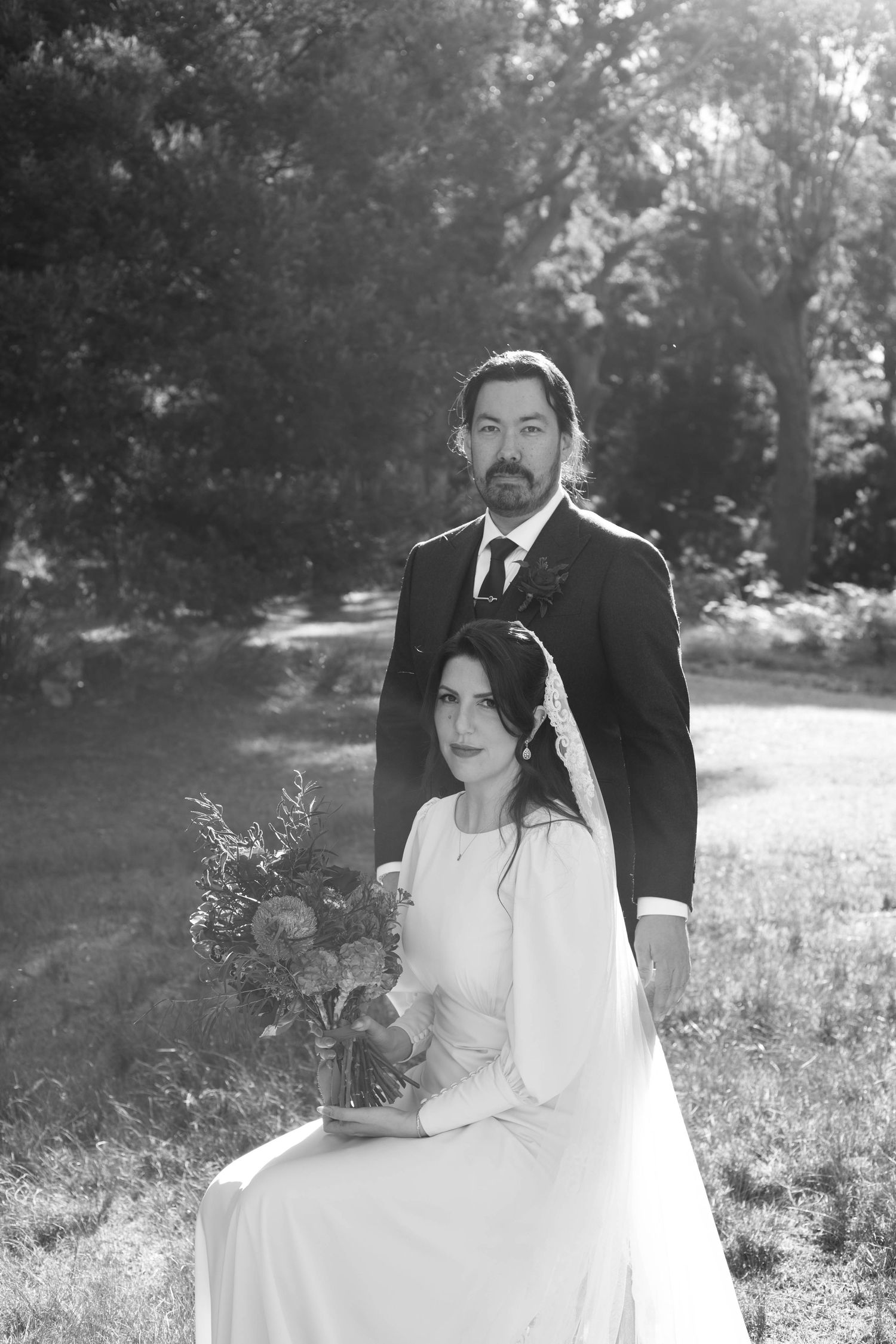 Wedding couple posing in a sunlit meadow for romantic portrait series.