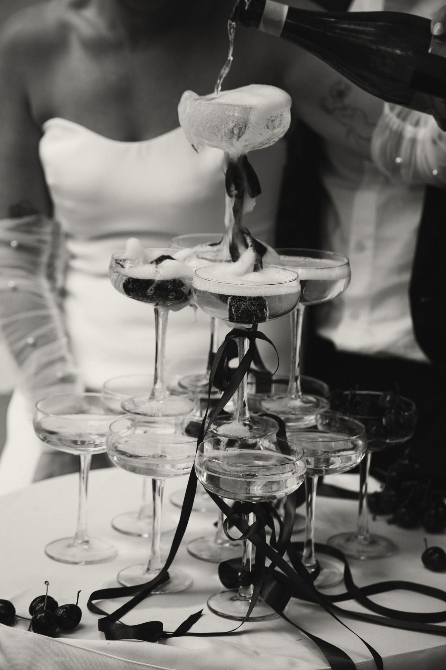 Champagne being poured into a tower of stacked crystal glasses at an elegant event.