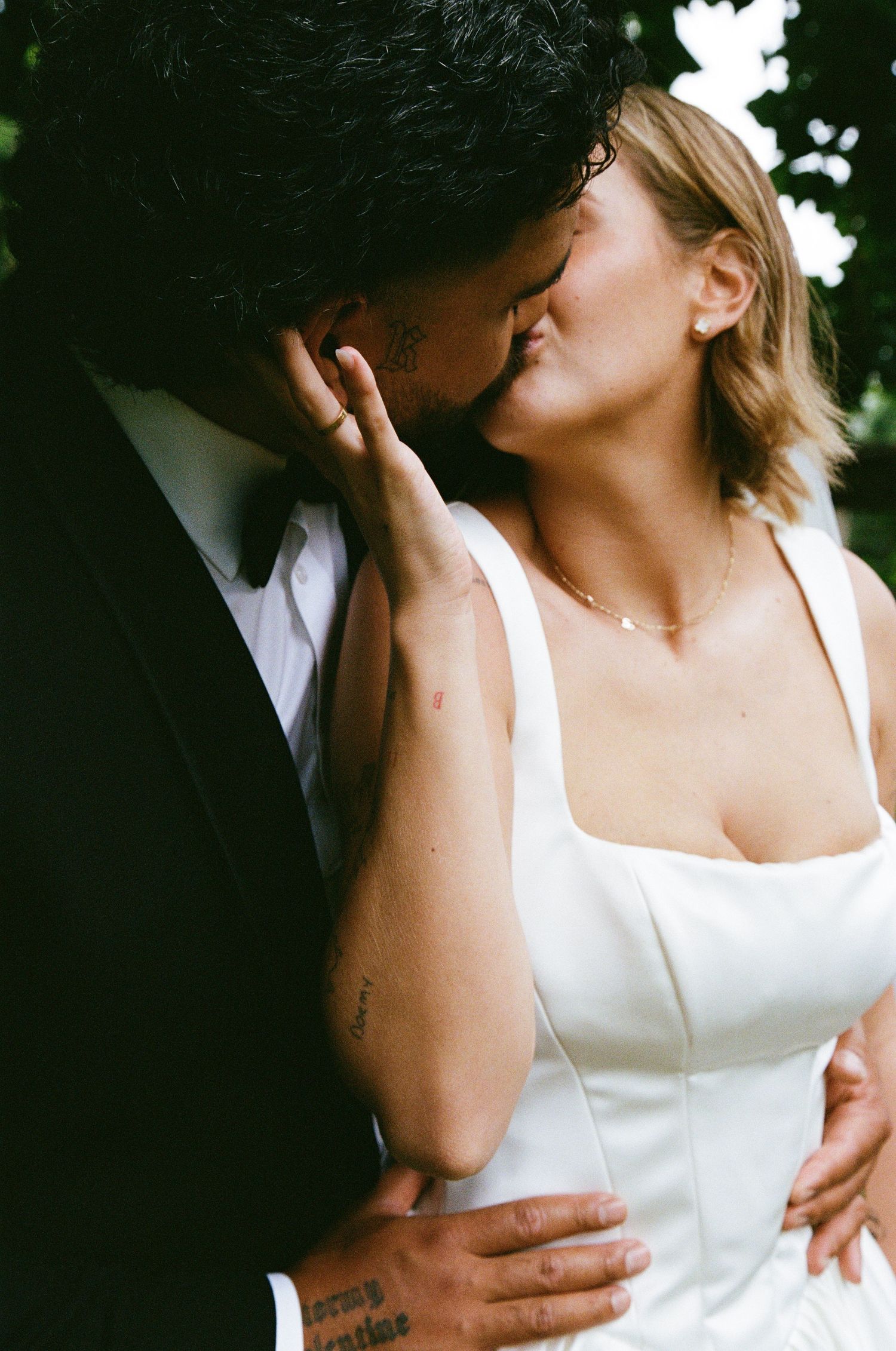 An intimate moment between newlyweds sharing a tender embrace outdoors.