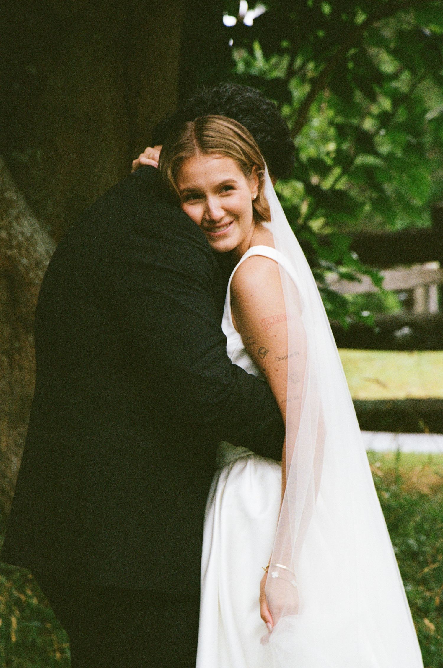 A romantic wedding moment captured in a garden setting with soft natural lighting.
