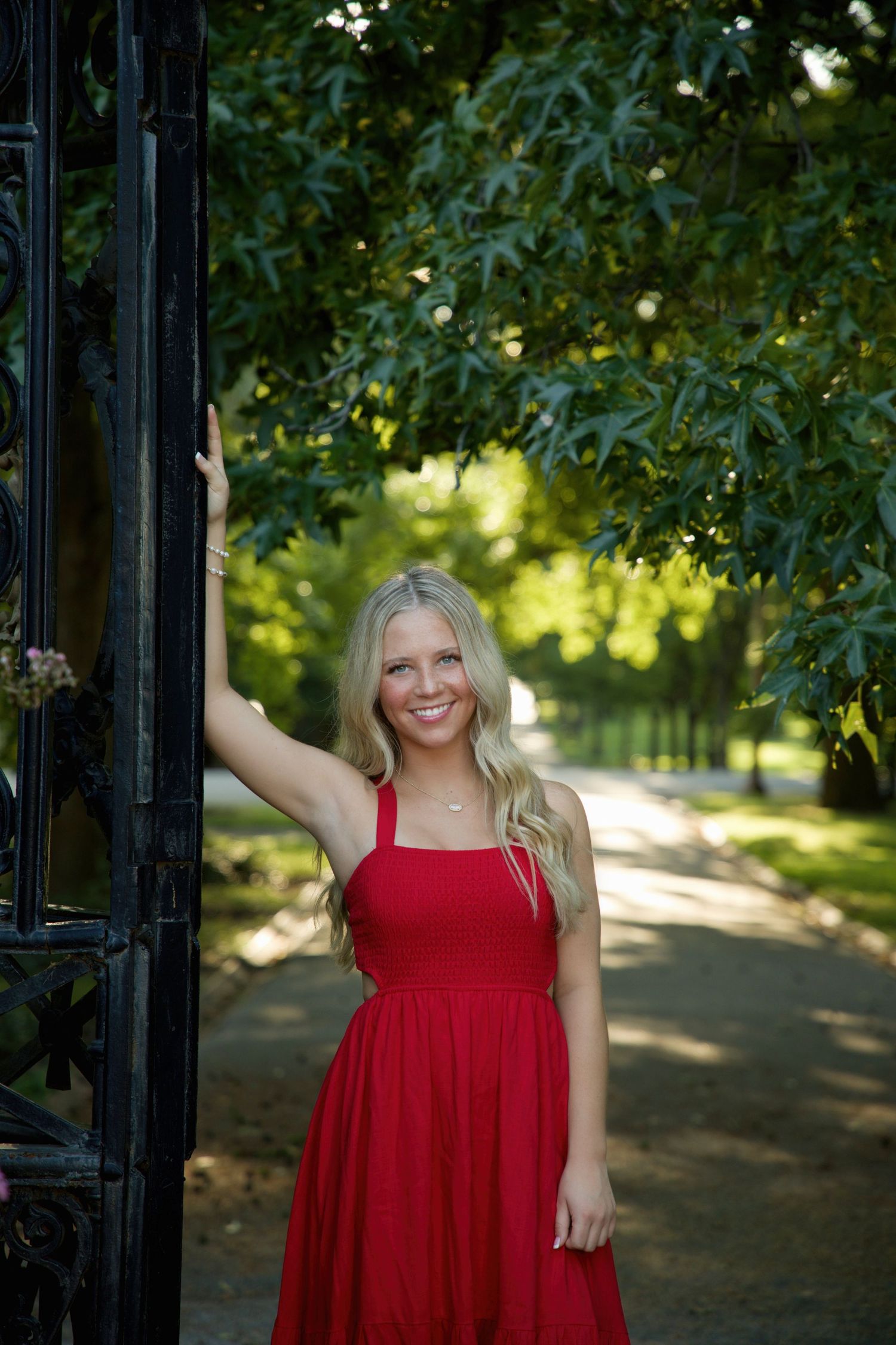 Senior portrait in red dress with iron fence by MJoy Photos
