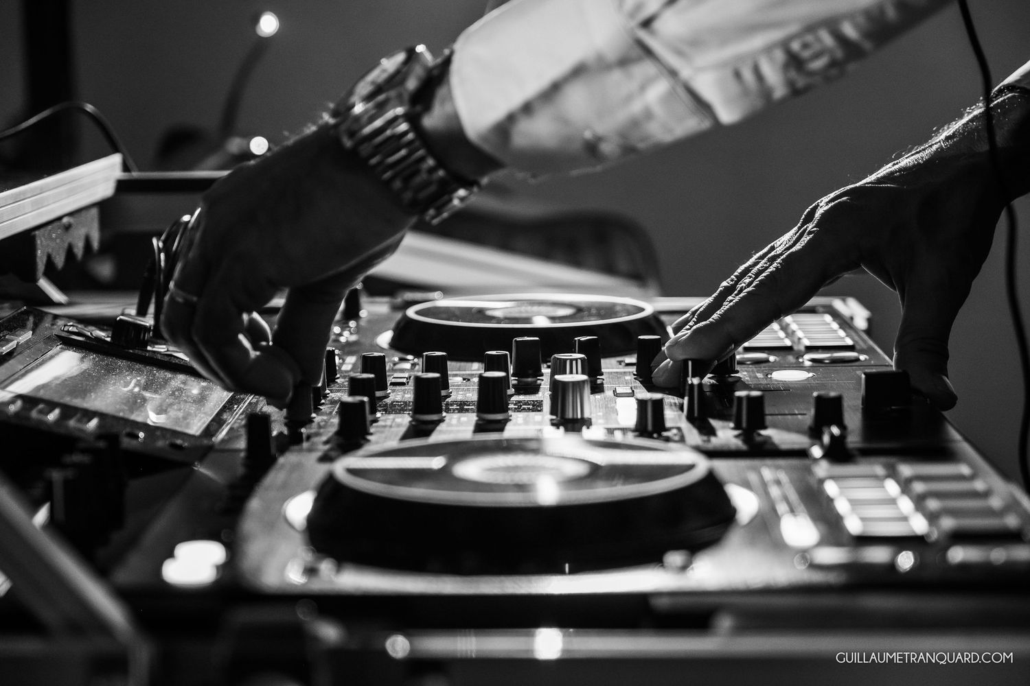 Black and white turntable and DJ equipment setup showing mixing controls and vinyl records.