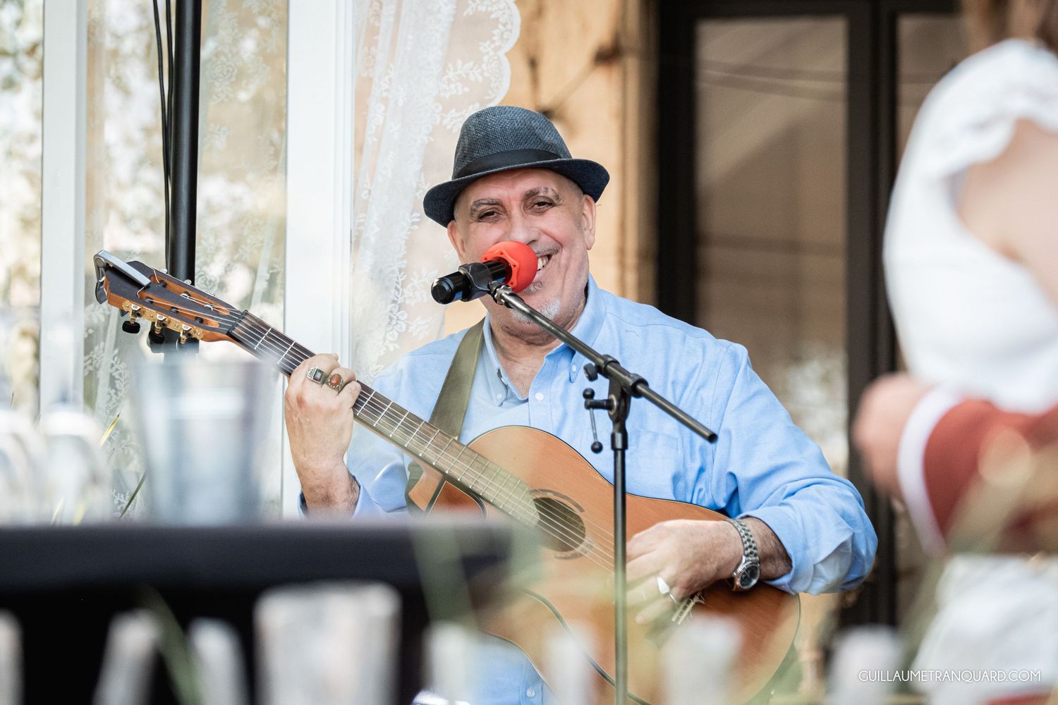 Musicians performing on outdoor stage with instruments and microphones.