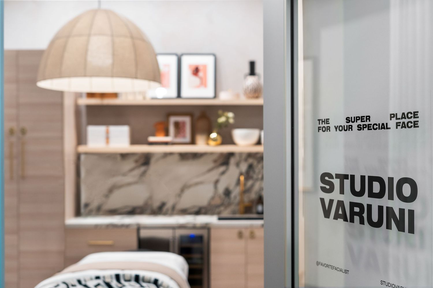 Modern storefront with glass windows and wooden accents displays a minimalist design studio interior.