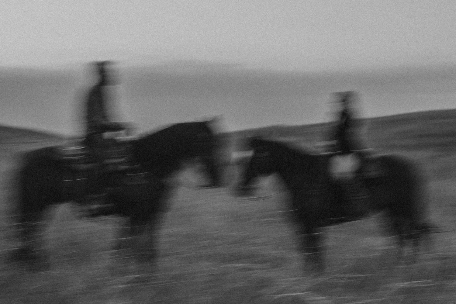 artistic black and white photography of a couple, each on a horse during a western styled photoshoot in Norco, California