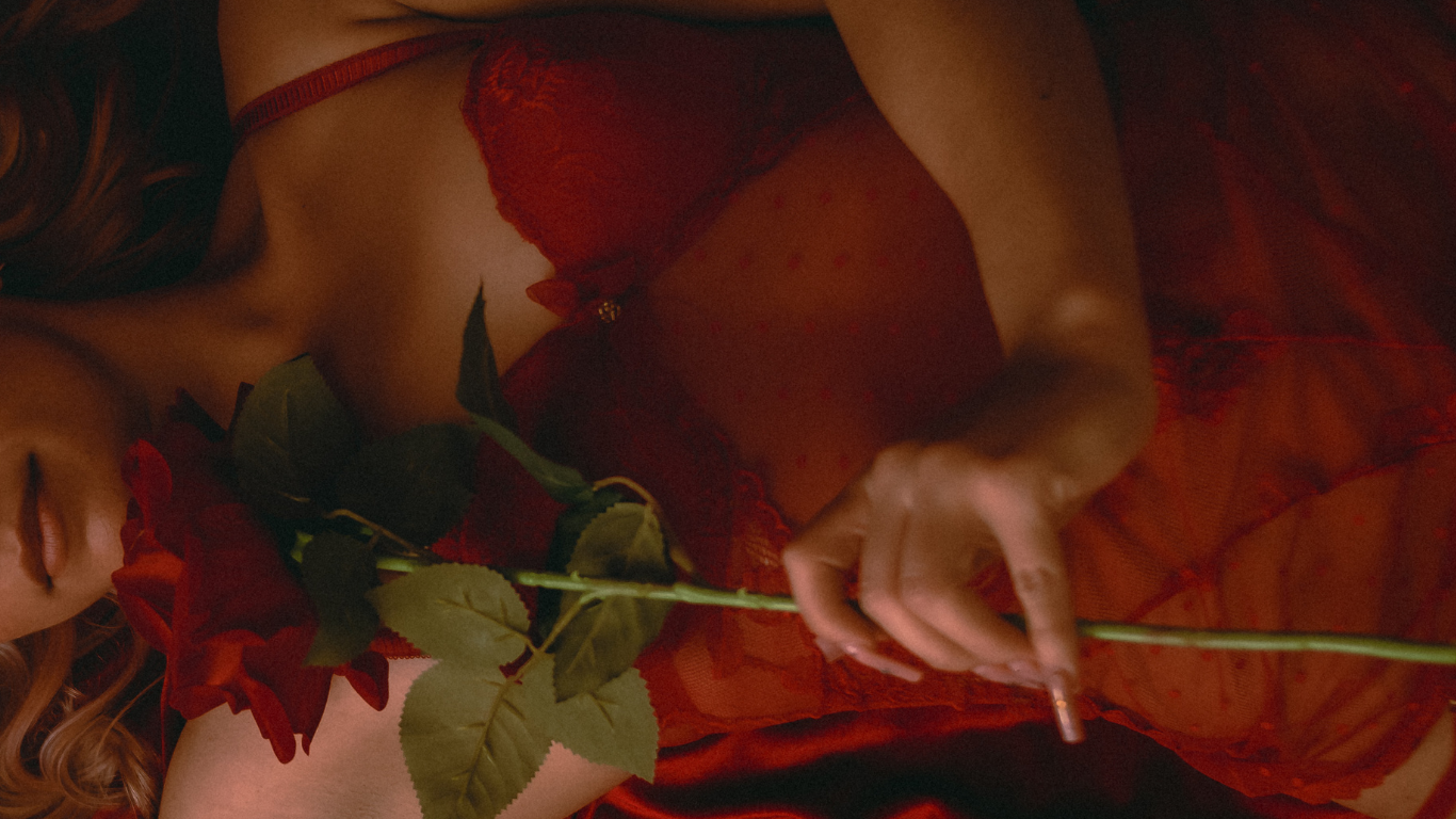 A romantic boudoir photography session with red roses, red backdrops, and red wardrobes for Valentine's day in Southern California.