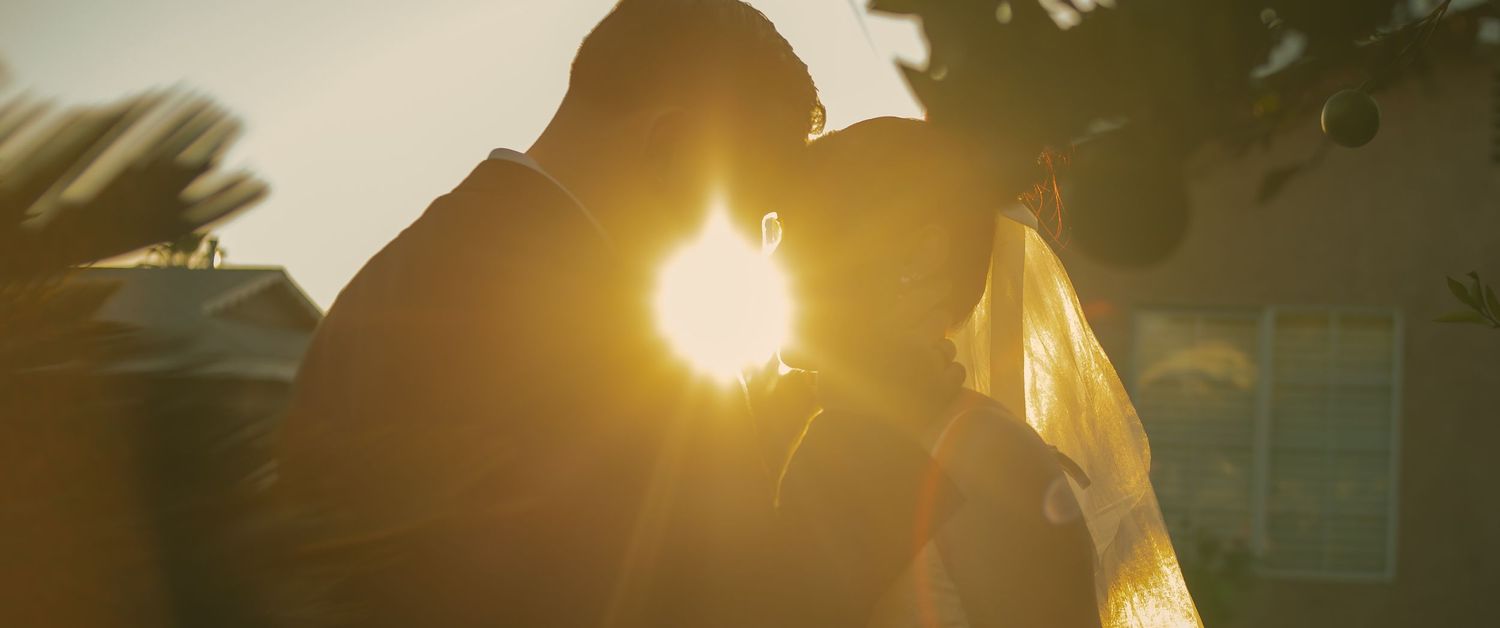 Cinematic sunset photo of bride and groom enjoying an intimate moment as the sunshine through their silhouettes in Los Angeles California