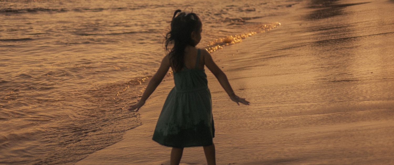 A family session photographed on a beach in SoCal at sunset like a happy ending movie scene.