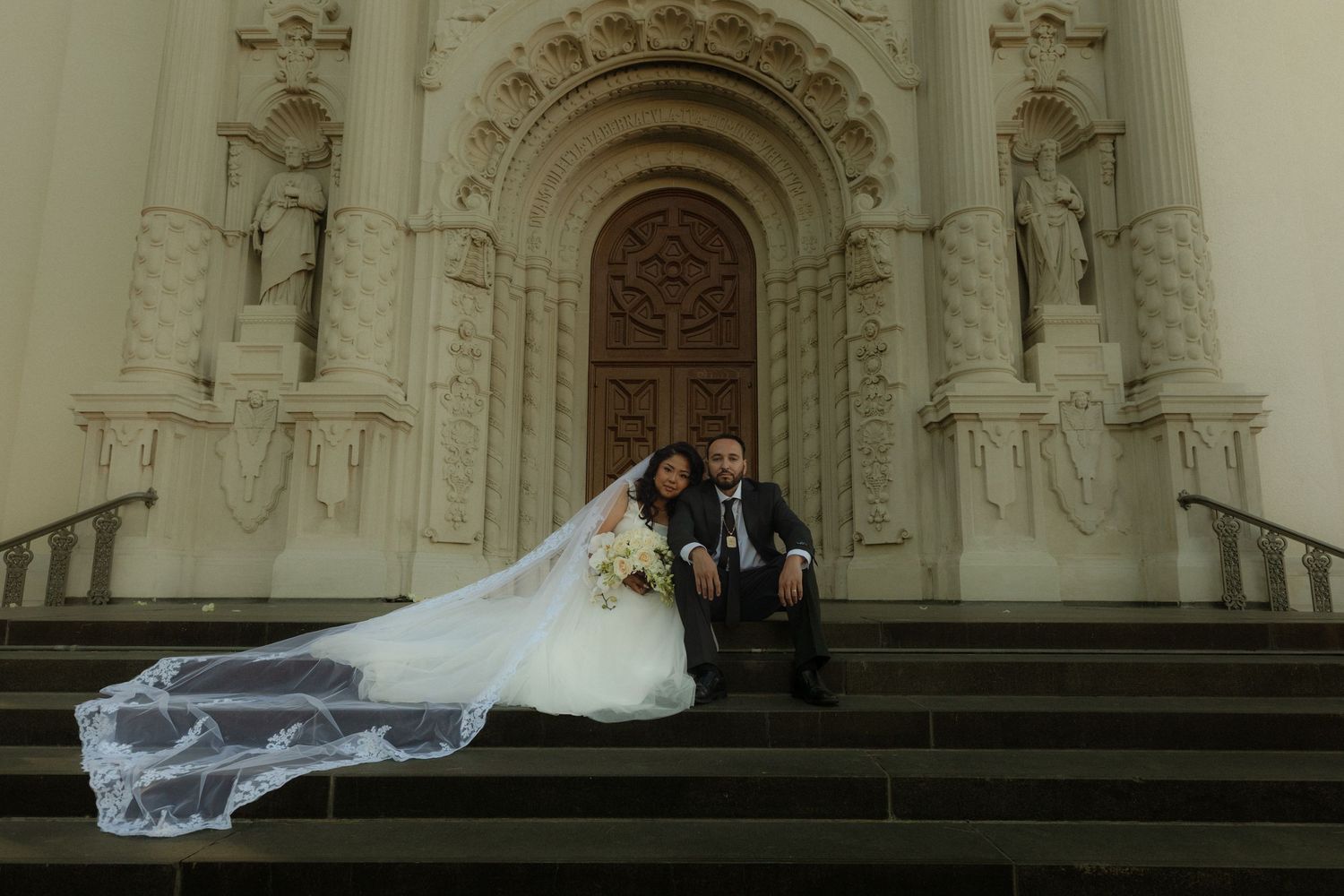 Cinematic wedding photography of a bride and groom in front of St. Vincent de Paul Catholic Church in Los Angeles.