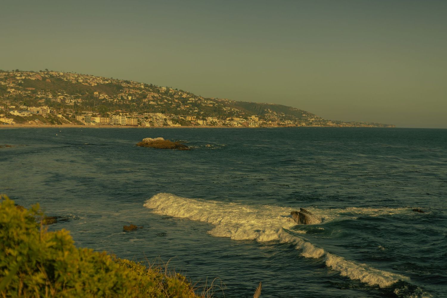 Panoramic sequence of coastal cliffs and waves crashing against the Catalina Island shoreline at sunset.