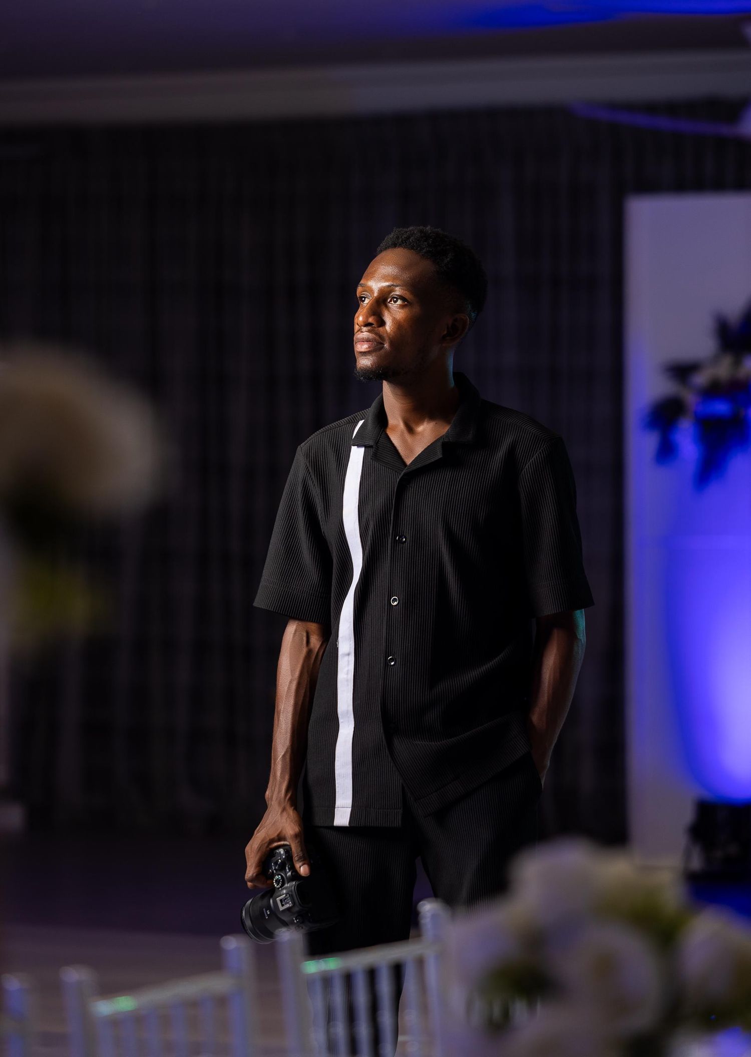 A dramatic stage performance with blue lighting and black attire.