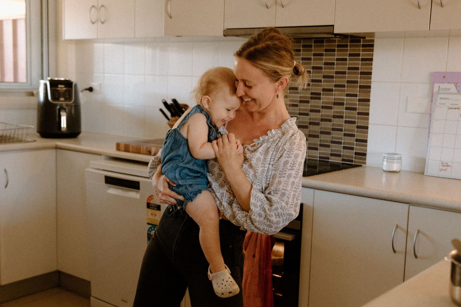 A motherhood photography session having a dance party in the kitchen in Wickham, WA