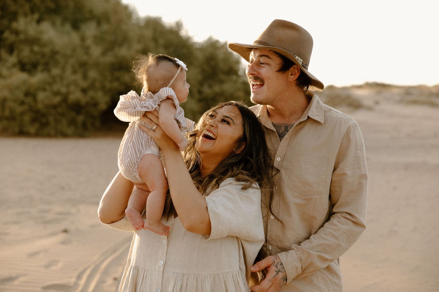 A family shares joyful laughter together during a golden hour family photography shoot in Karratha, WA