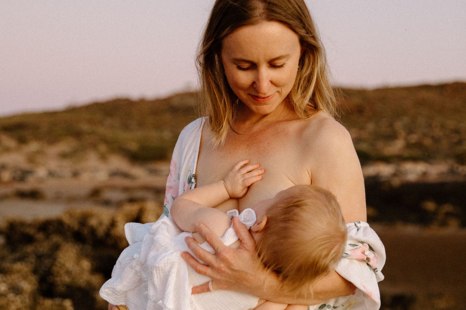 Intimate breastfeeding moment captured during golden sunset light, in a motherhood photography session in Wickham, WA
