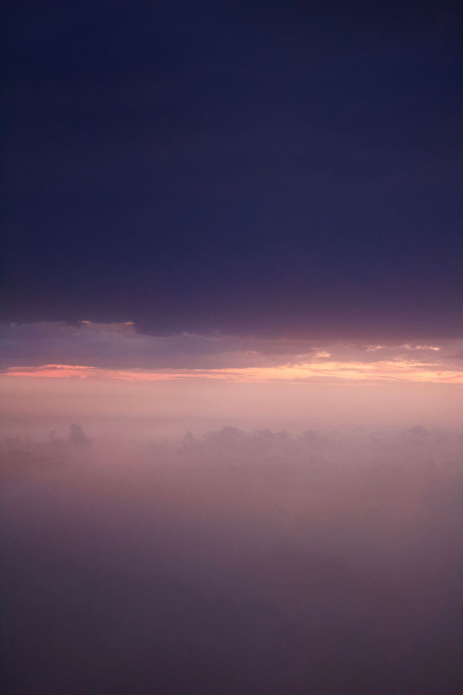 Purple sunset clouds and mist above the Balearic Sea, between Spain and Mallorca, featuring deep violet, indigo, lavender, and pink hues.