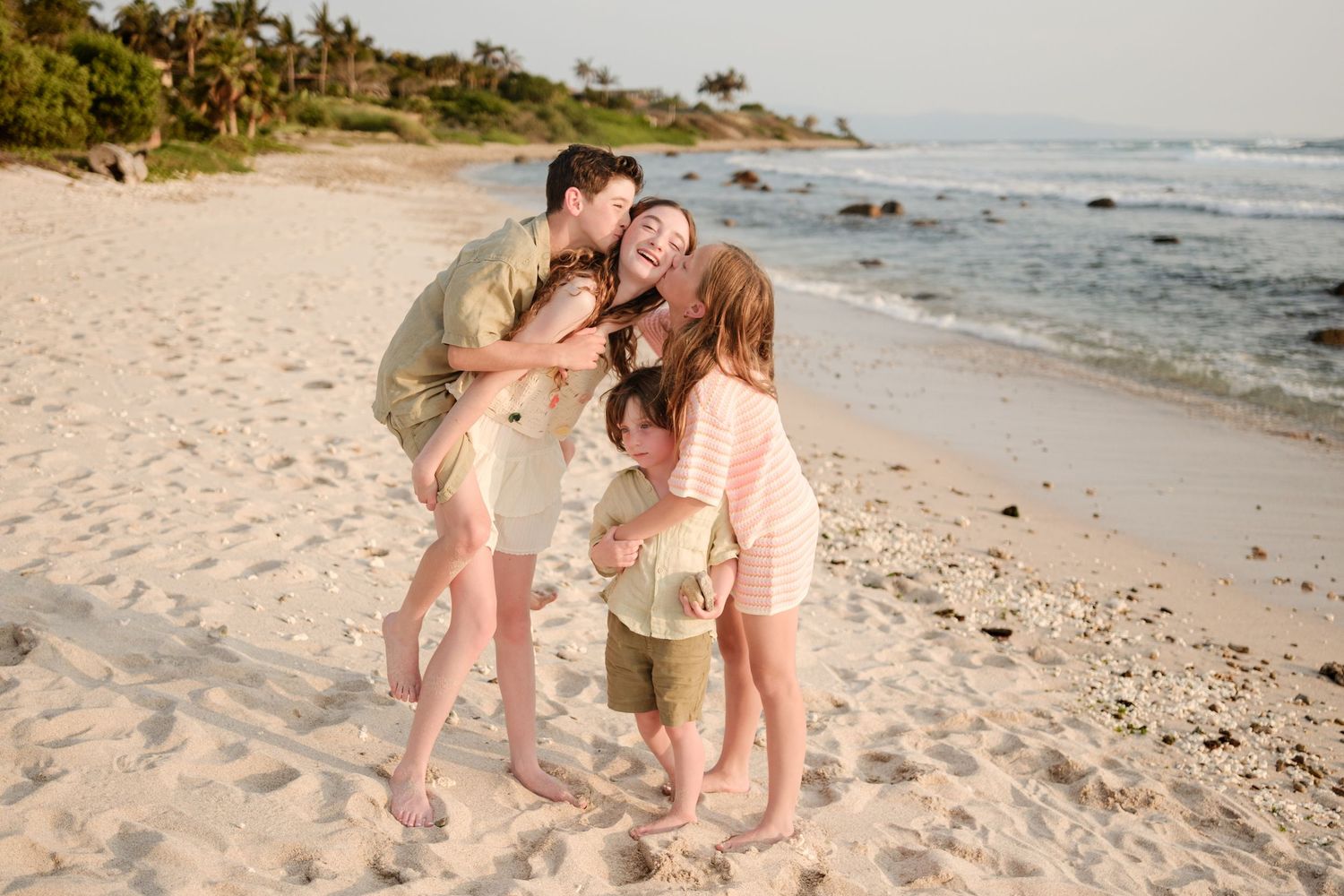 People enjoying a romantic photoshoot together on a scenic Hawaiian beach during golden hour sunset.
