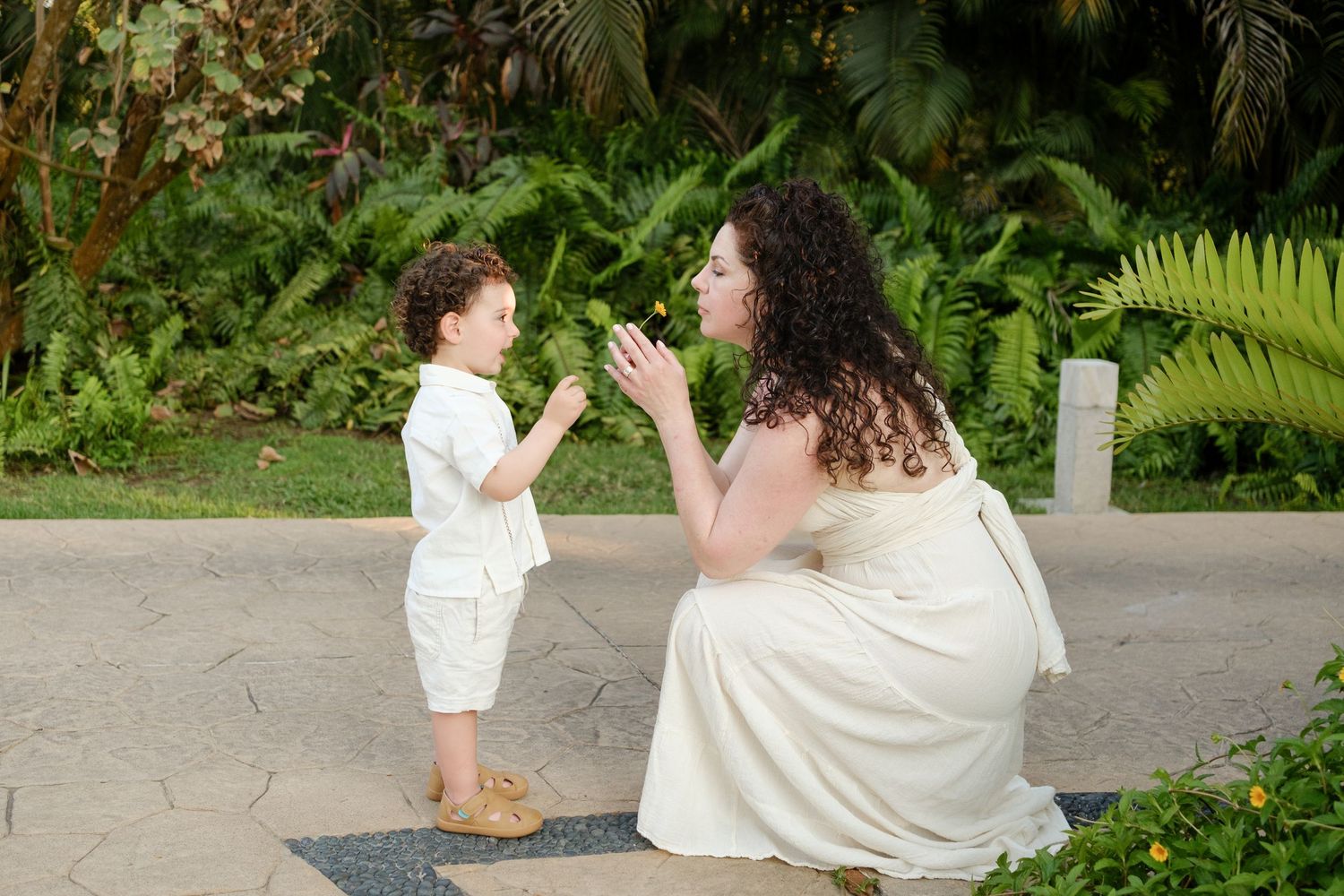 Riviera Nayarit family photographer, mother and child sharing a quiet moment surrounded by tropical foliage.