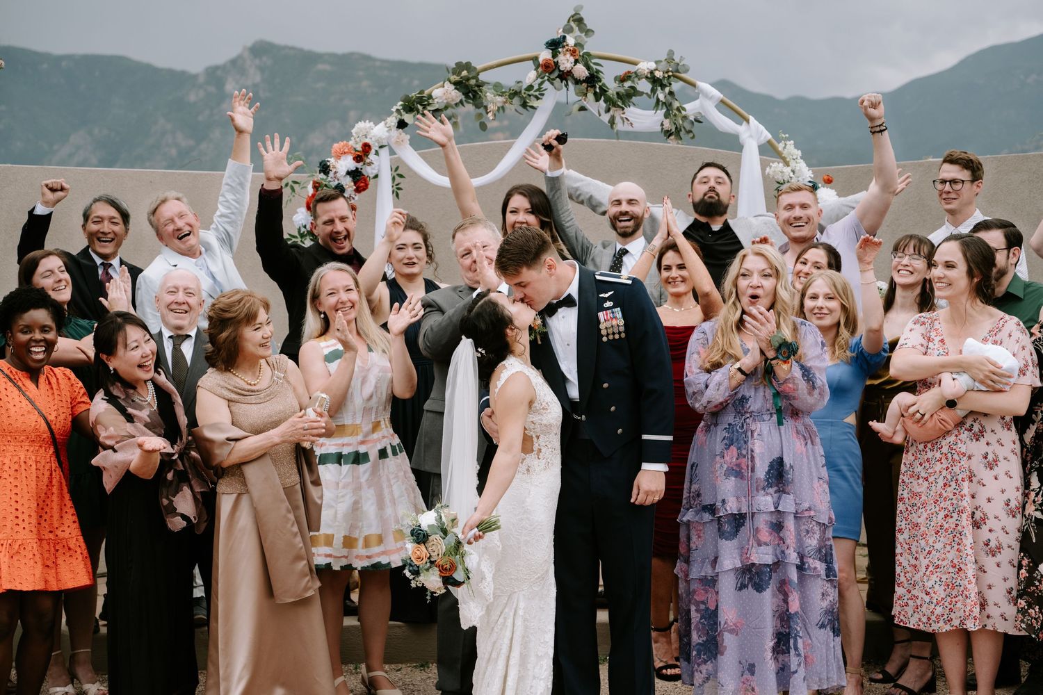 A series of joyful wedding celebration photos showing guests dancing and celebrating under floral decorations.