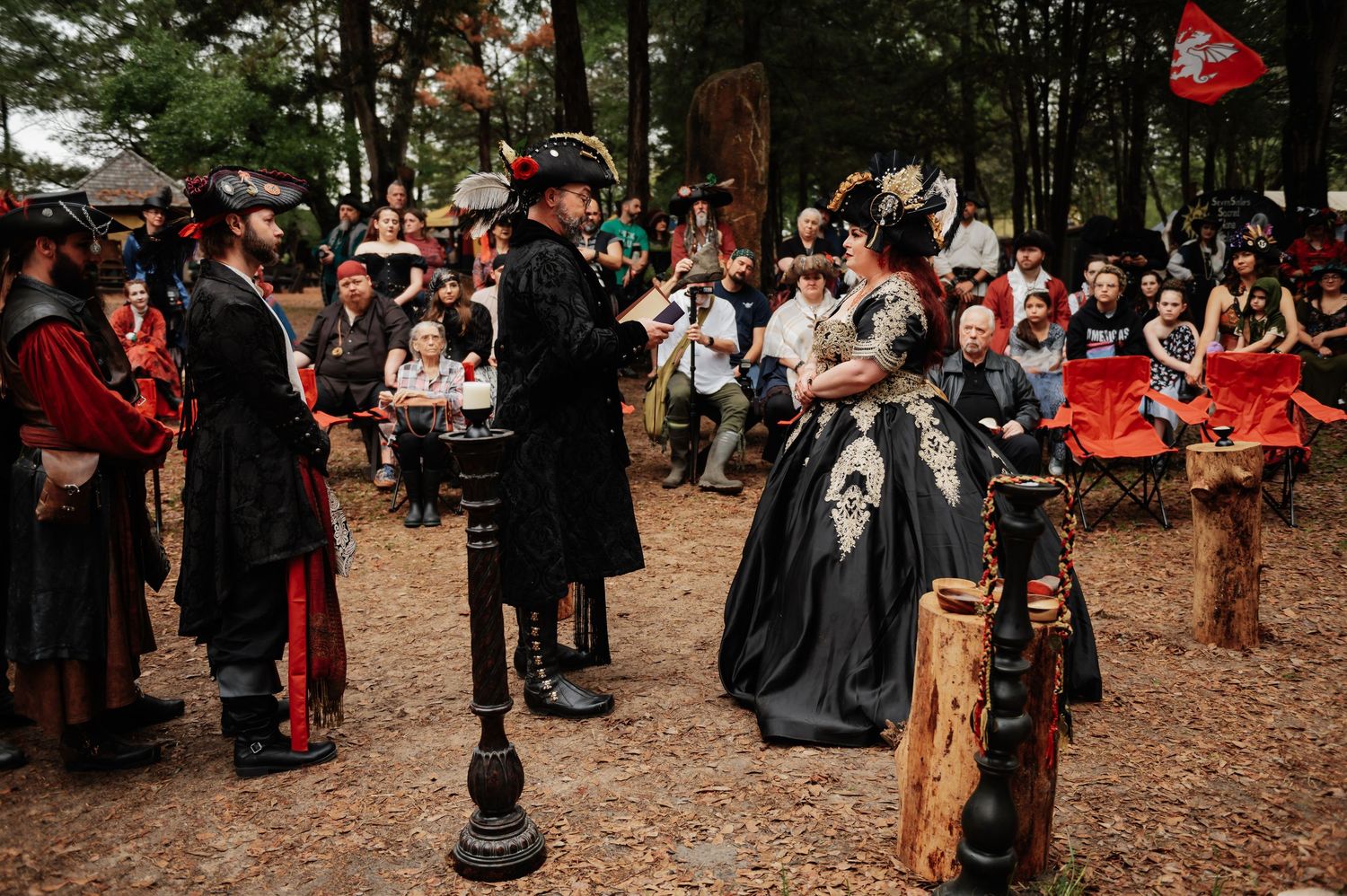 Costumed performers in pirate attire gather at an outdoor Renaissance festival event.