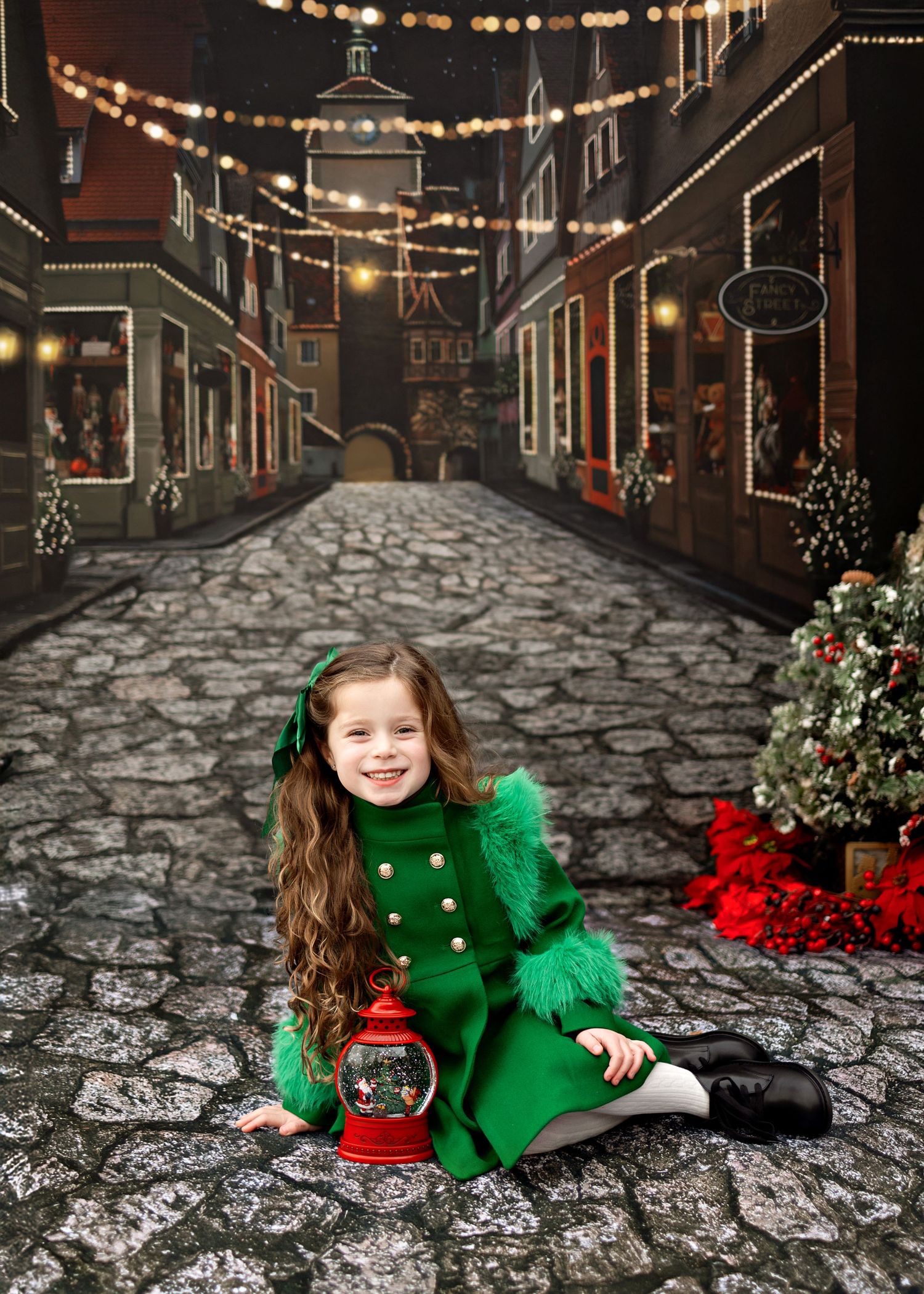 A cobblestone street decorated for Christmas with glowing string lights and storefronts features cozy holiday scenery.