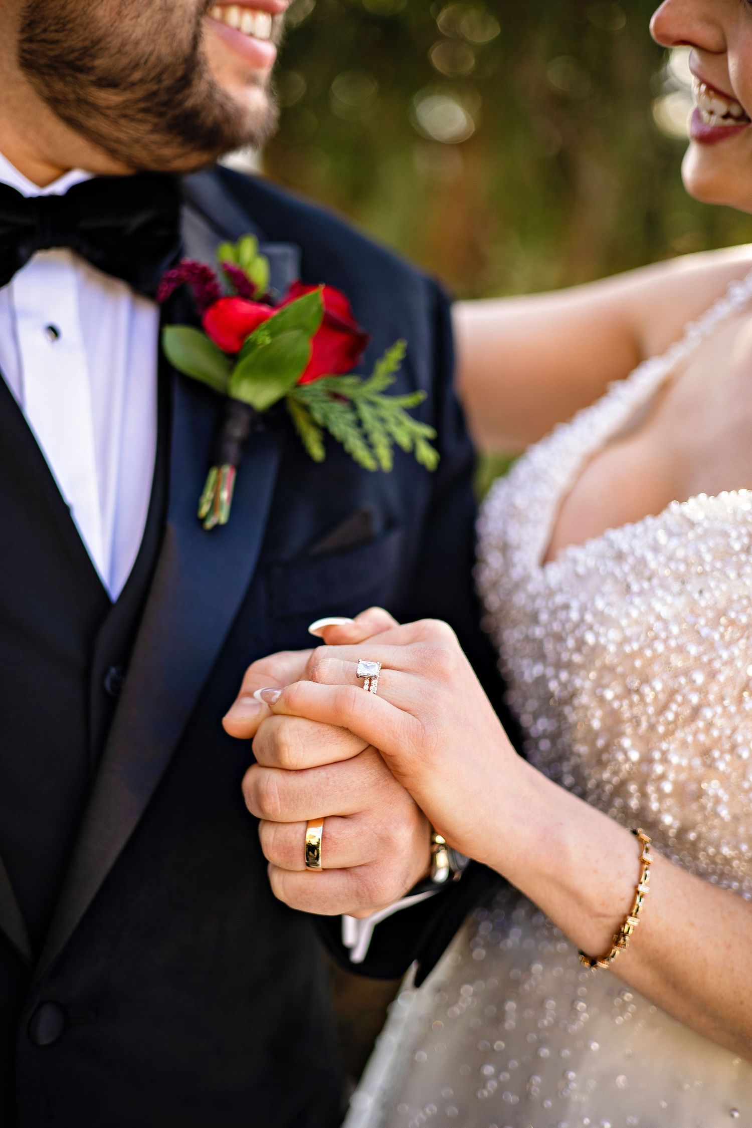 Close-up sequence of hands exchanging wedding rings during a ceremony with sparkly dress details.