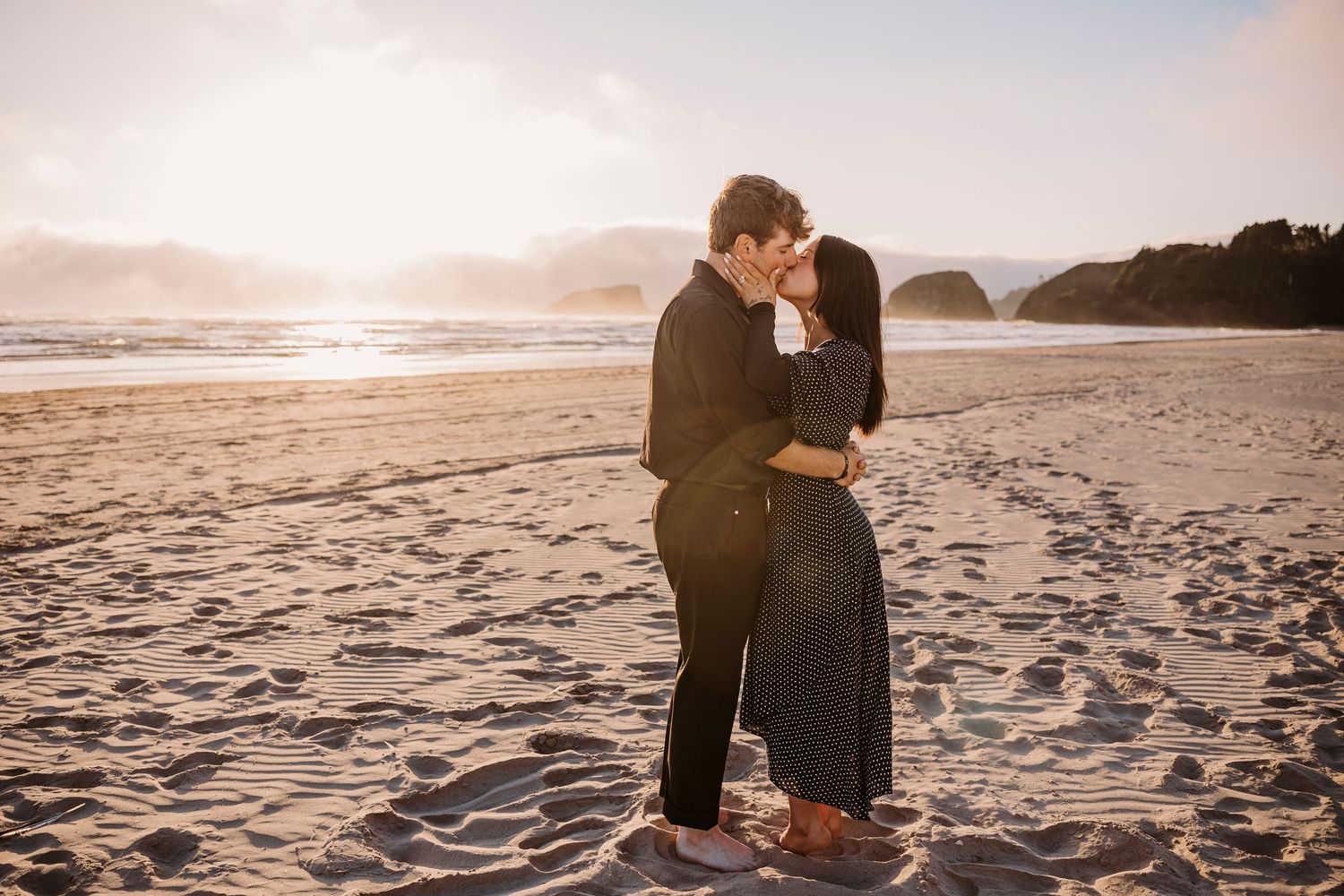 Romantic beach engagement photos during golden hour with ocean waves in background.