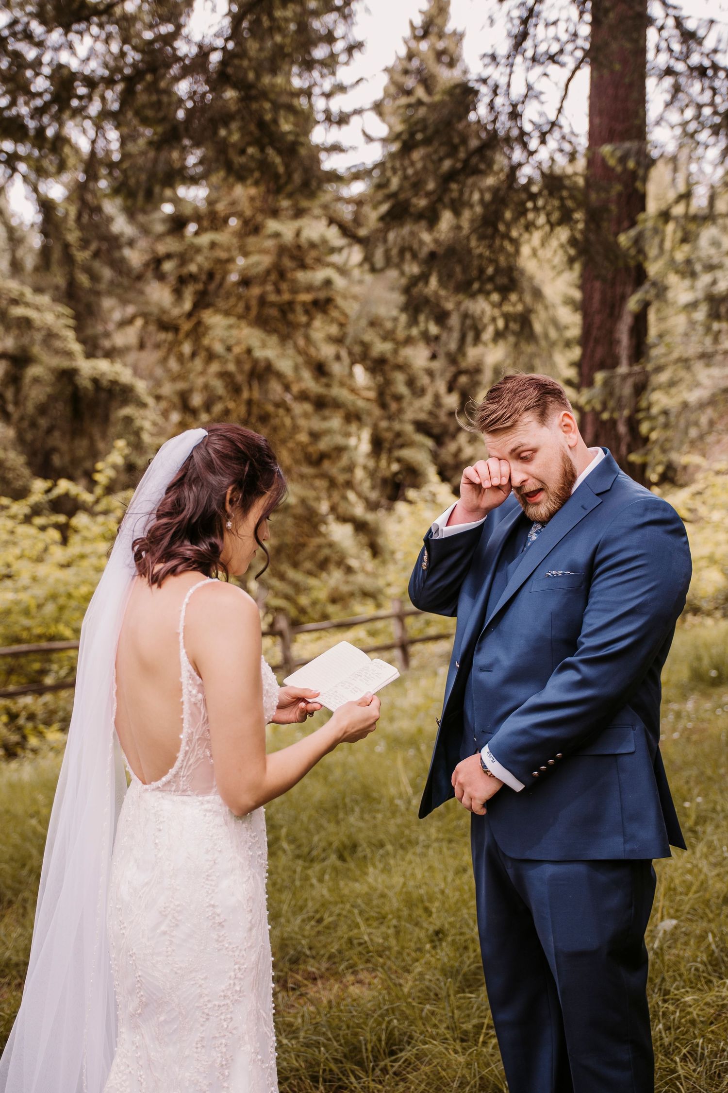 A romantic first look sequence between newlyweds in a wooded outdoor setting.