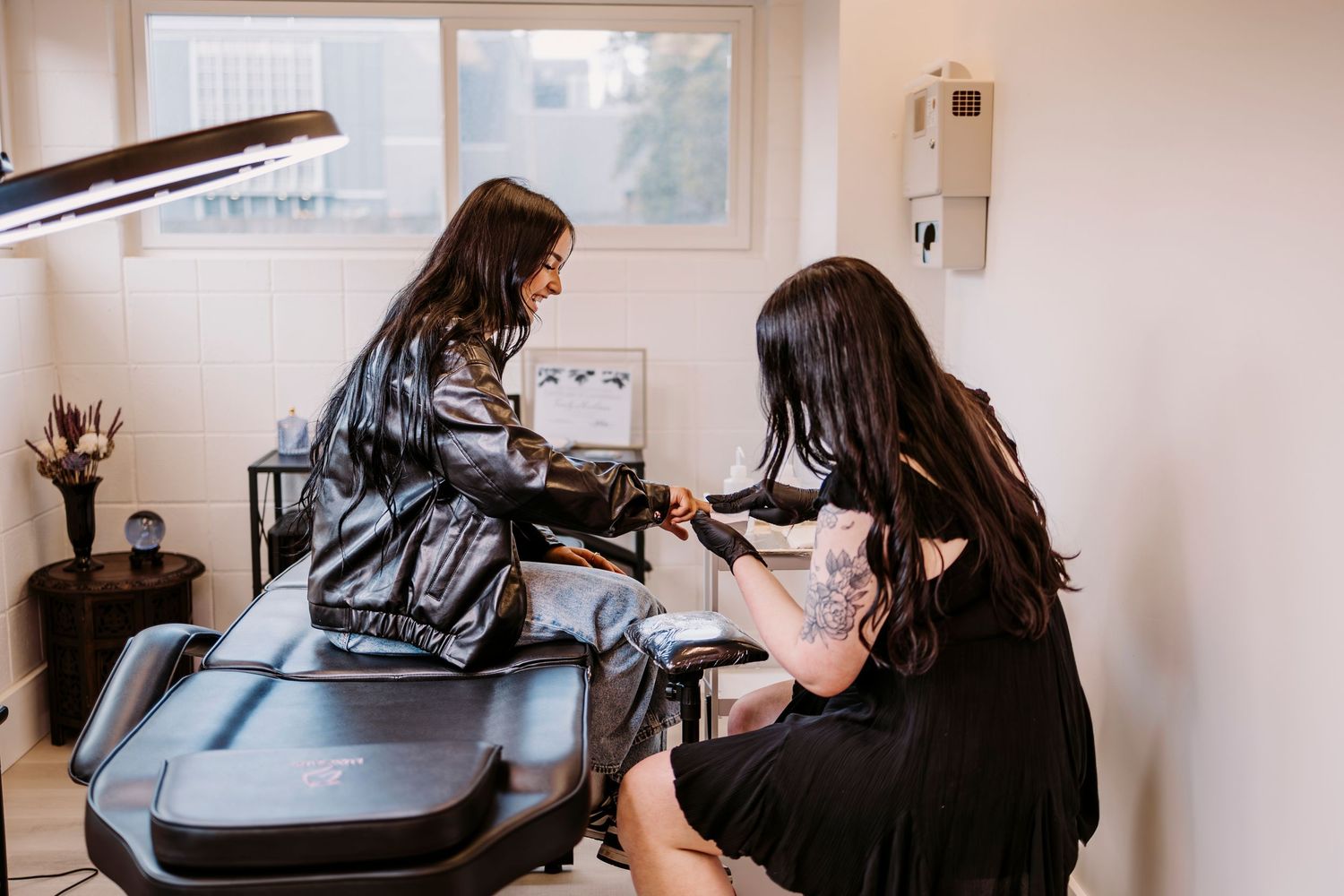 Lash artist working on a client in a bright, modern salon setting.