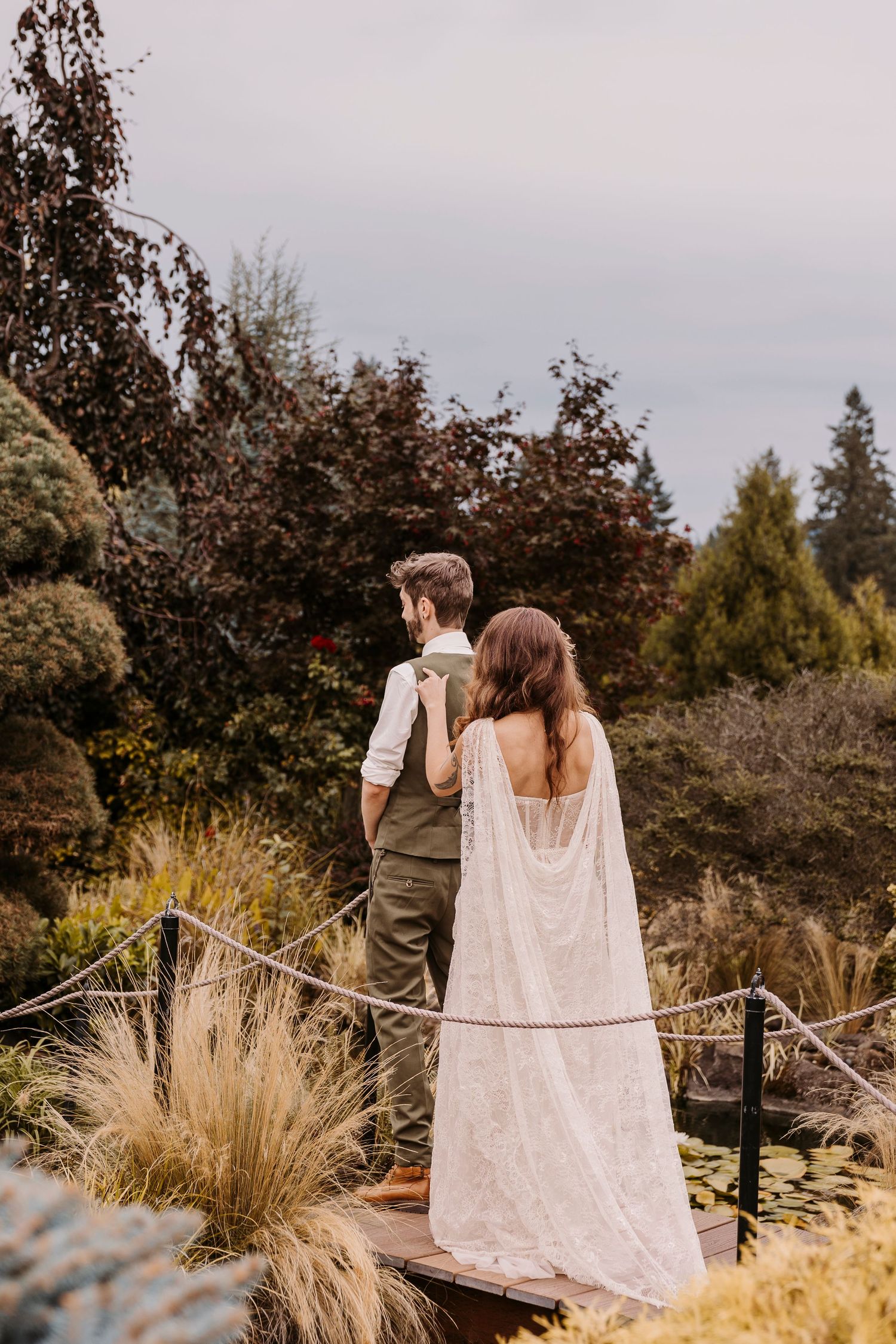 Couple walking through a garden pathway with ornamental grasses and autumn foliage.