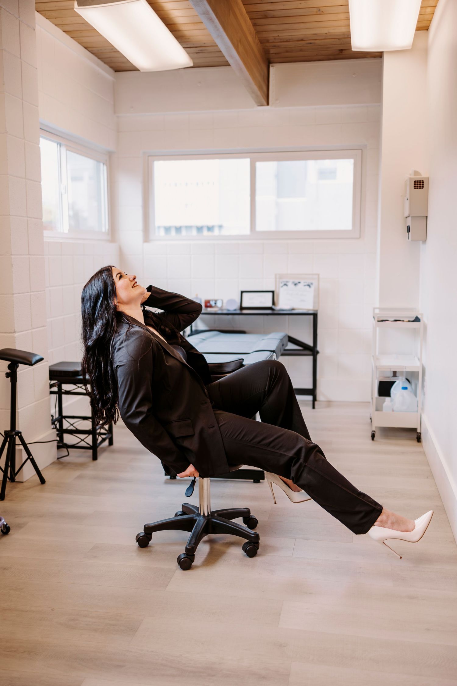 Creative poses on black salon chair in bright studio space.