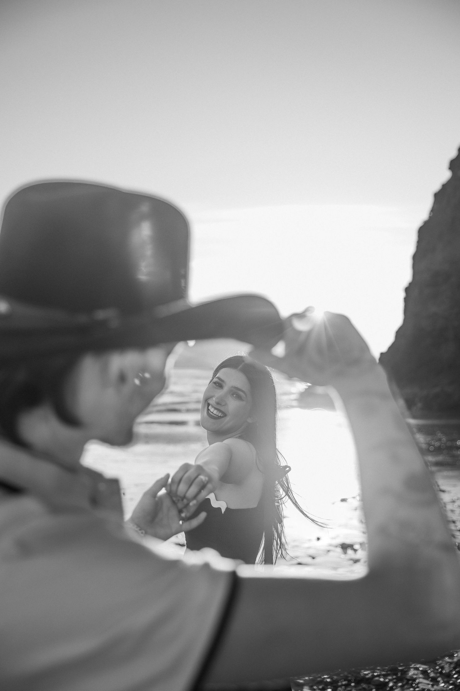 Black and white beach portraits showing intimate moments between a couple at sunset.