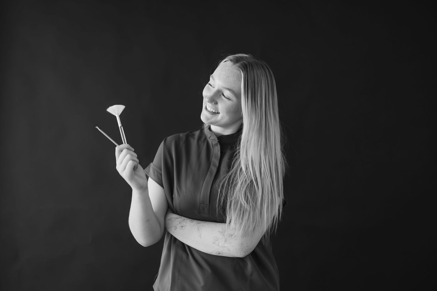 Side profile portrait against black background showing professional beauty tools.