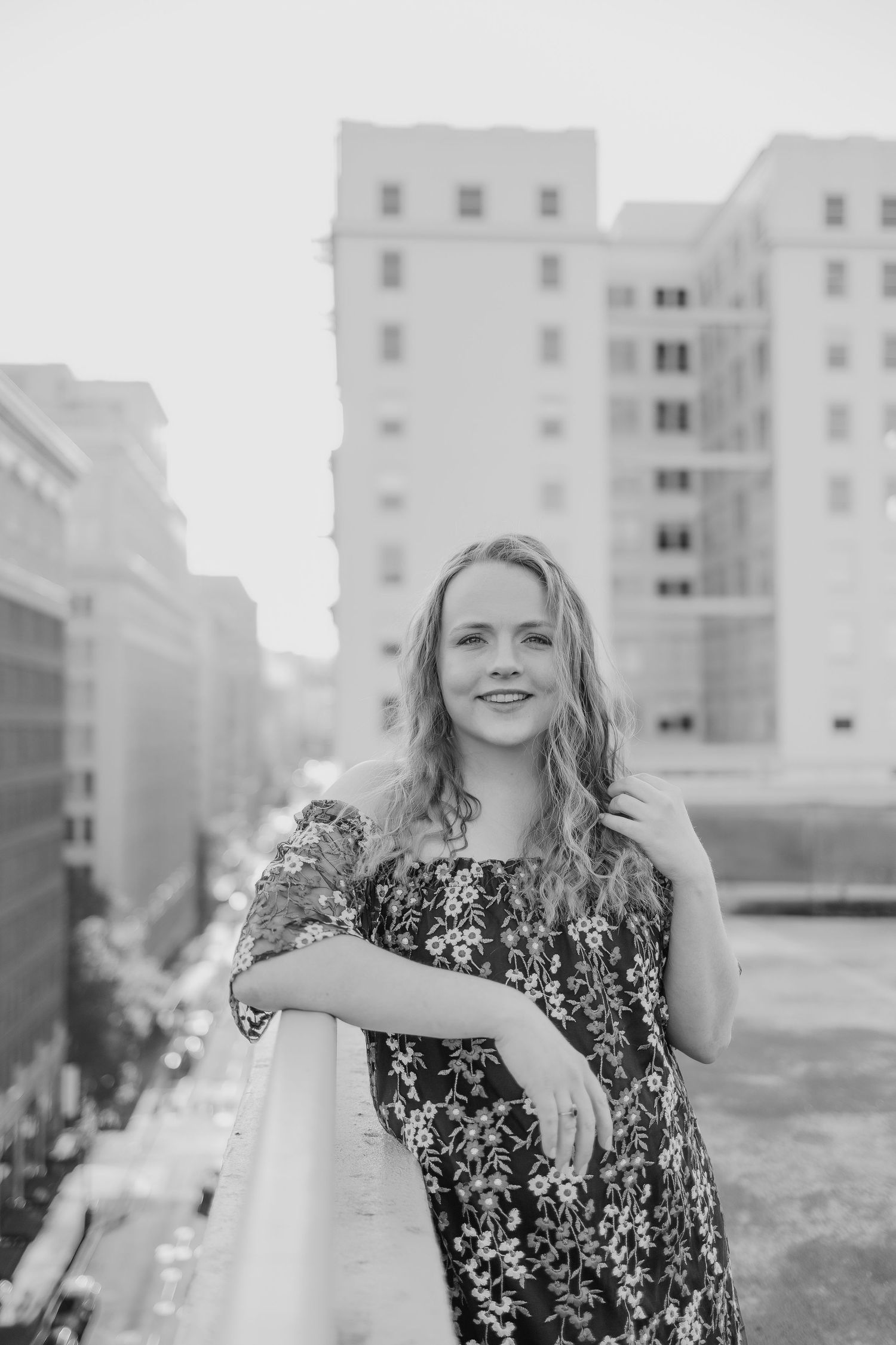 Black and white rooftop portrait with cityscape background.