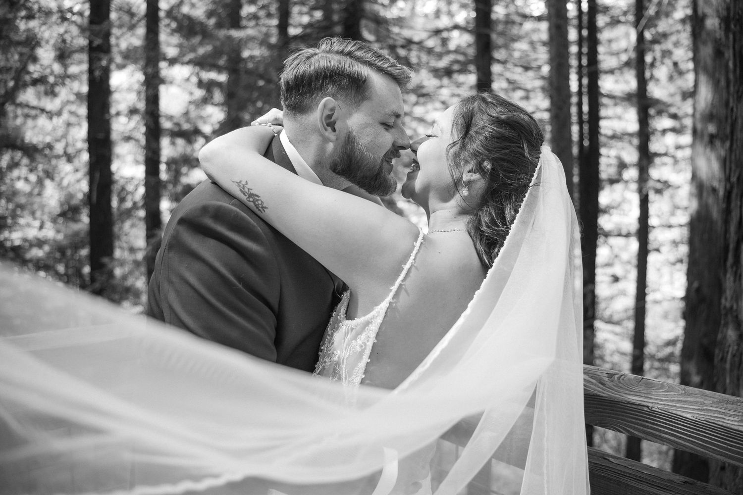Flowing white veil creates romantic atmosphere during forest wedding photoshoot.