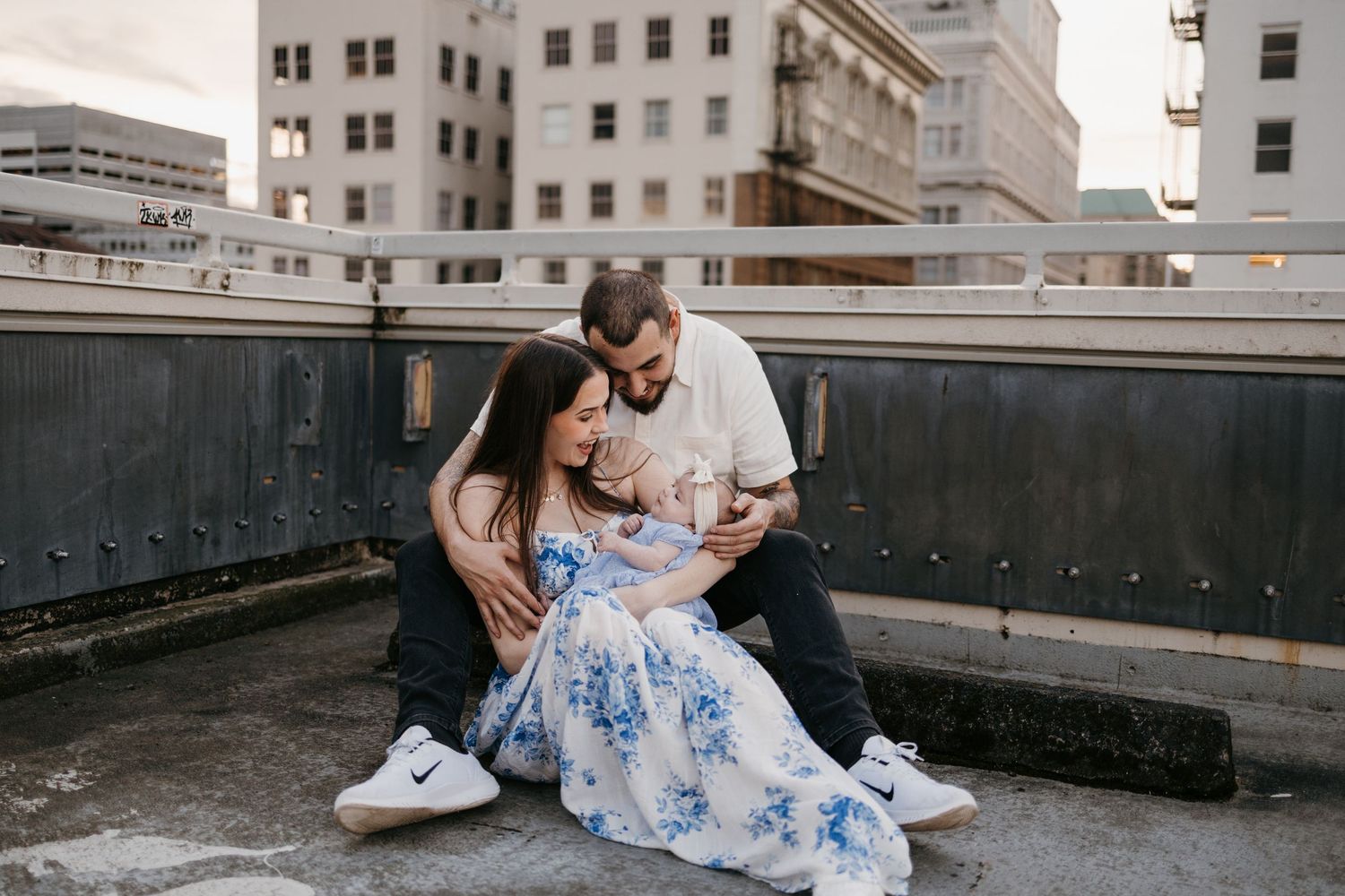 Romantic urban photoshoot on concrete rooftop with cityscape views.
