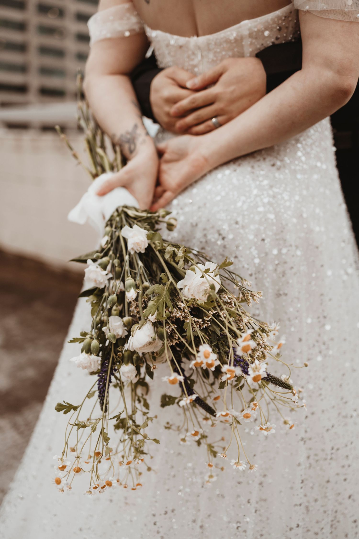 Detail shots of dried flower bouquet against sparkly wedding dress.
