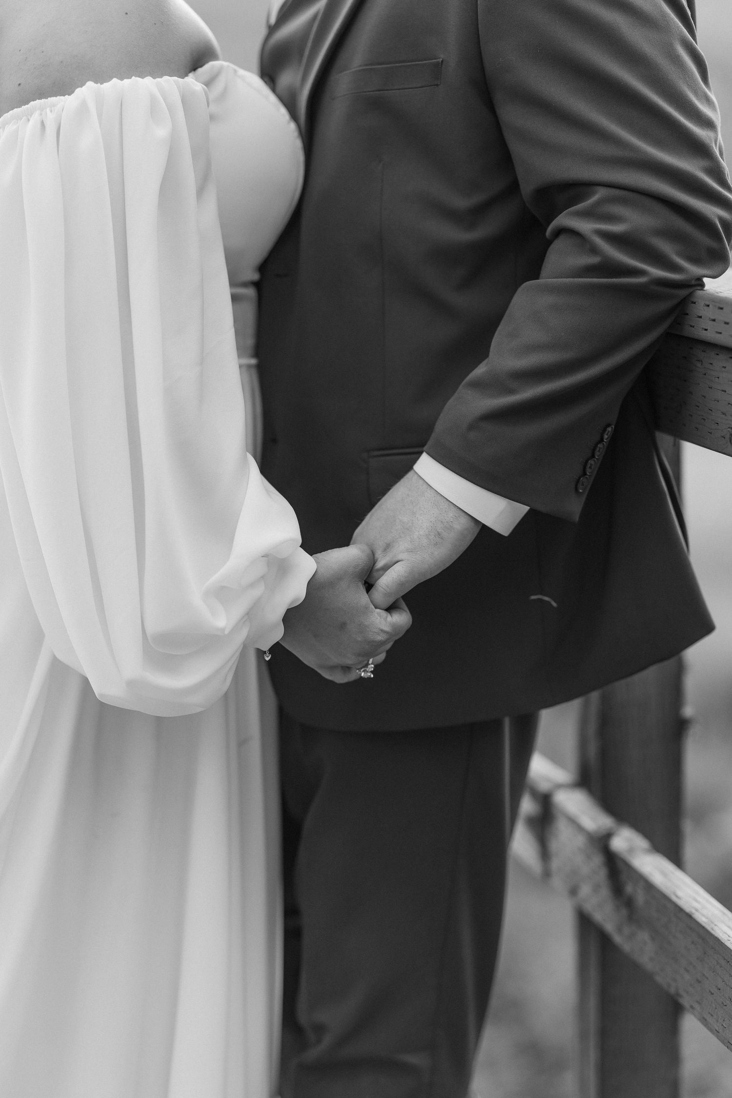 Close-up detail of a couple embracing during a wedding ceremony in formal attire.