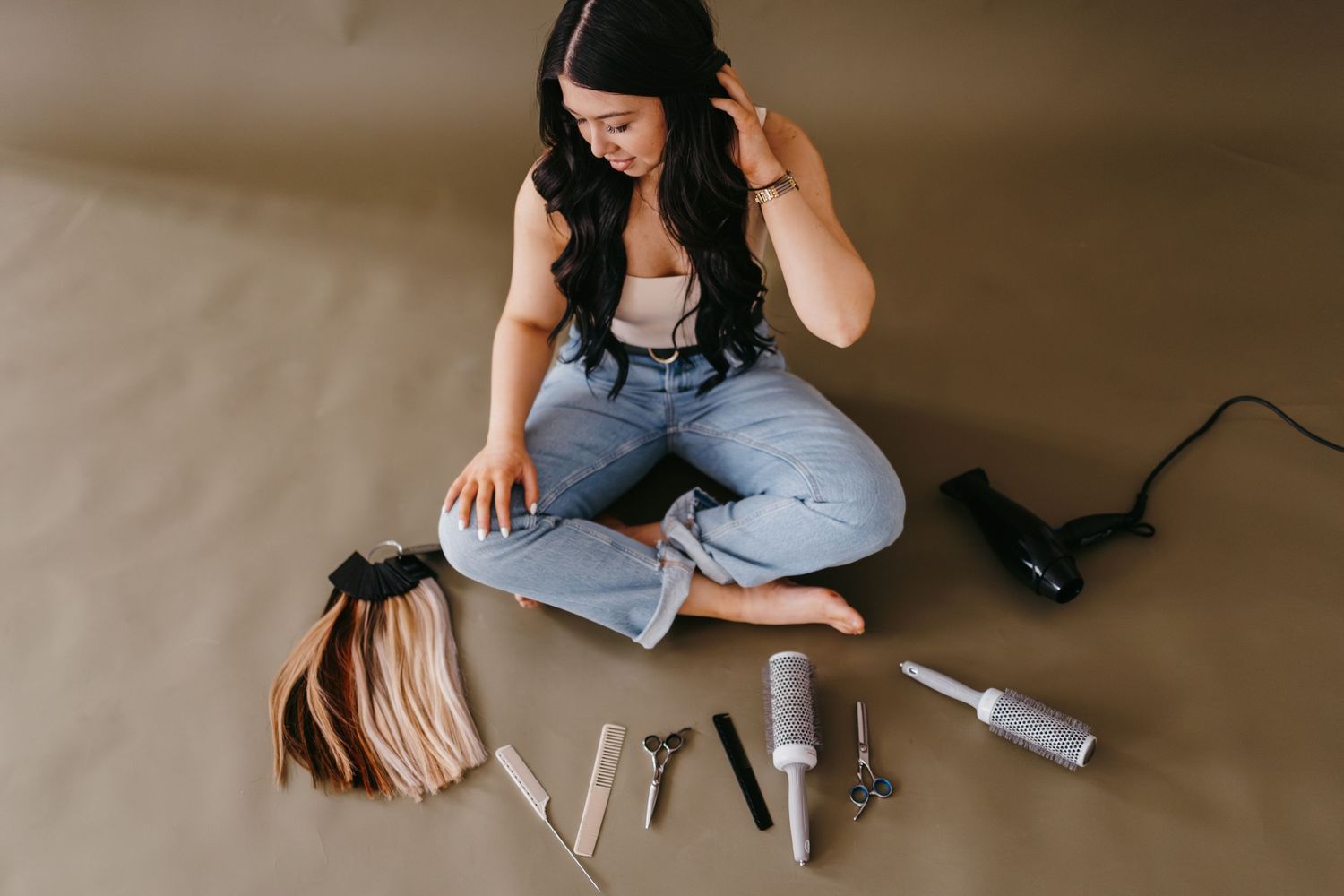Beauty tools and styling equipment arranged on brown floor.