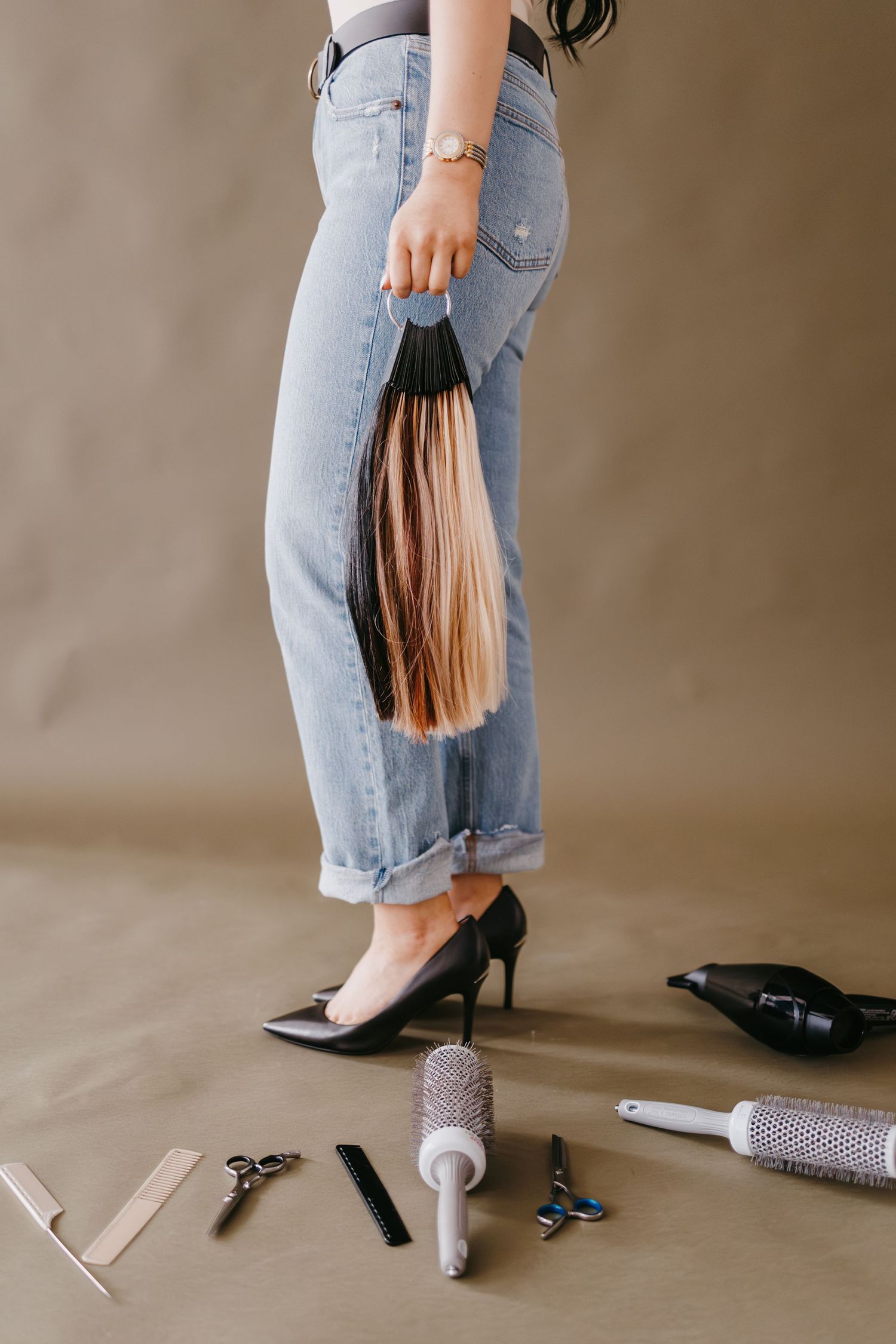 Hair styling tools and accessories scattered on floor with person in jeans.
