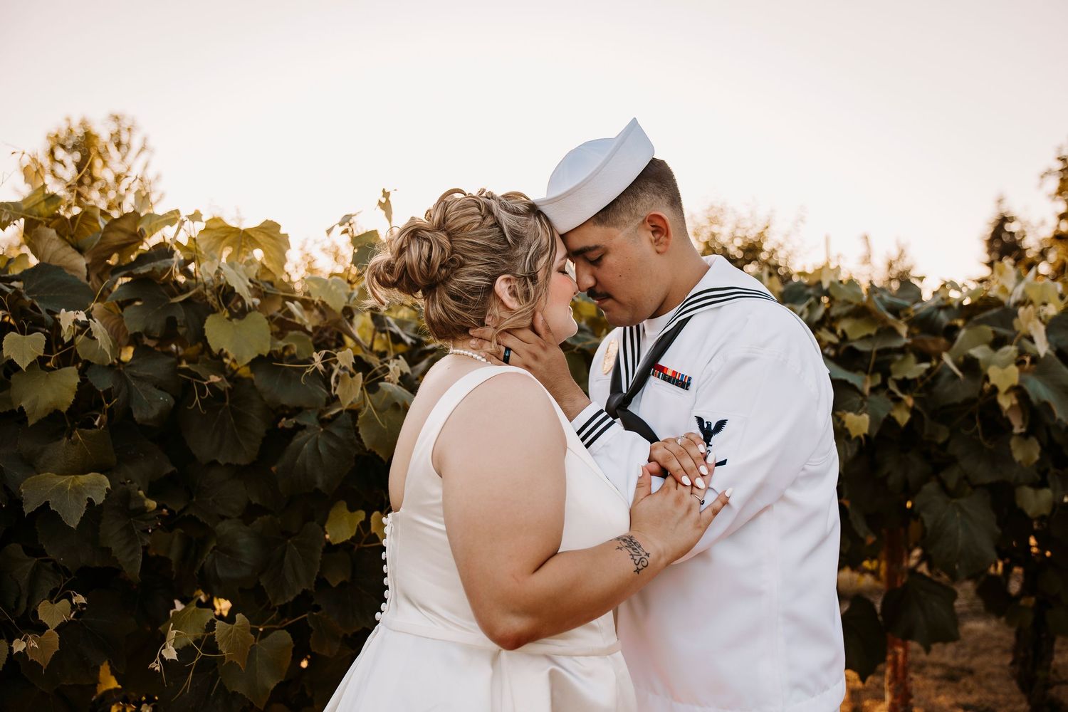 Romantic couple shares intimate moments in a vineyard at sunset.