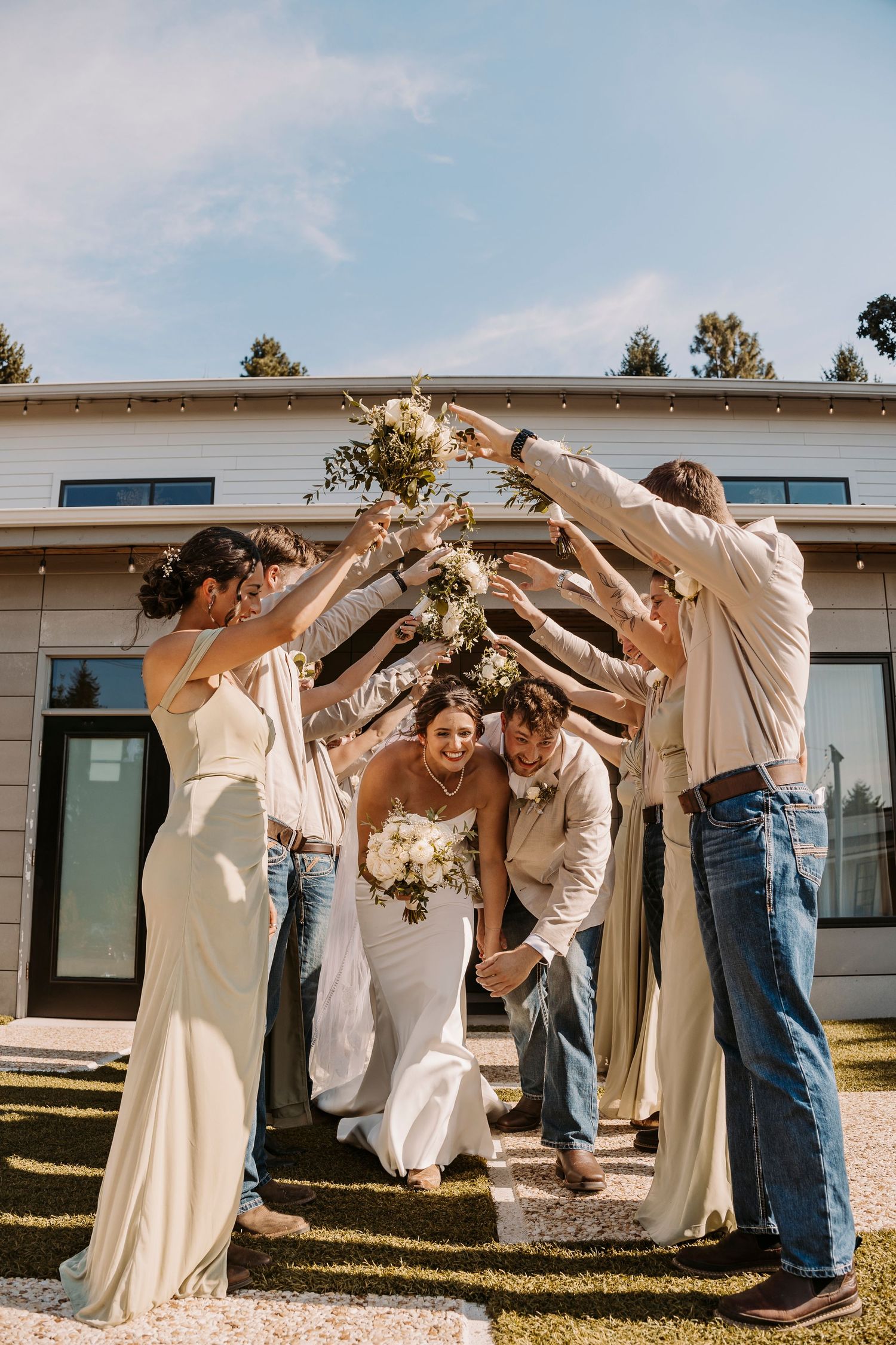 Wedding party forming an arch tunnel with their arms for celebration.