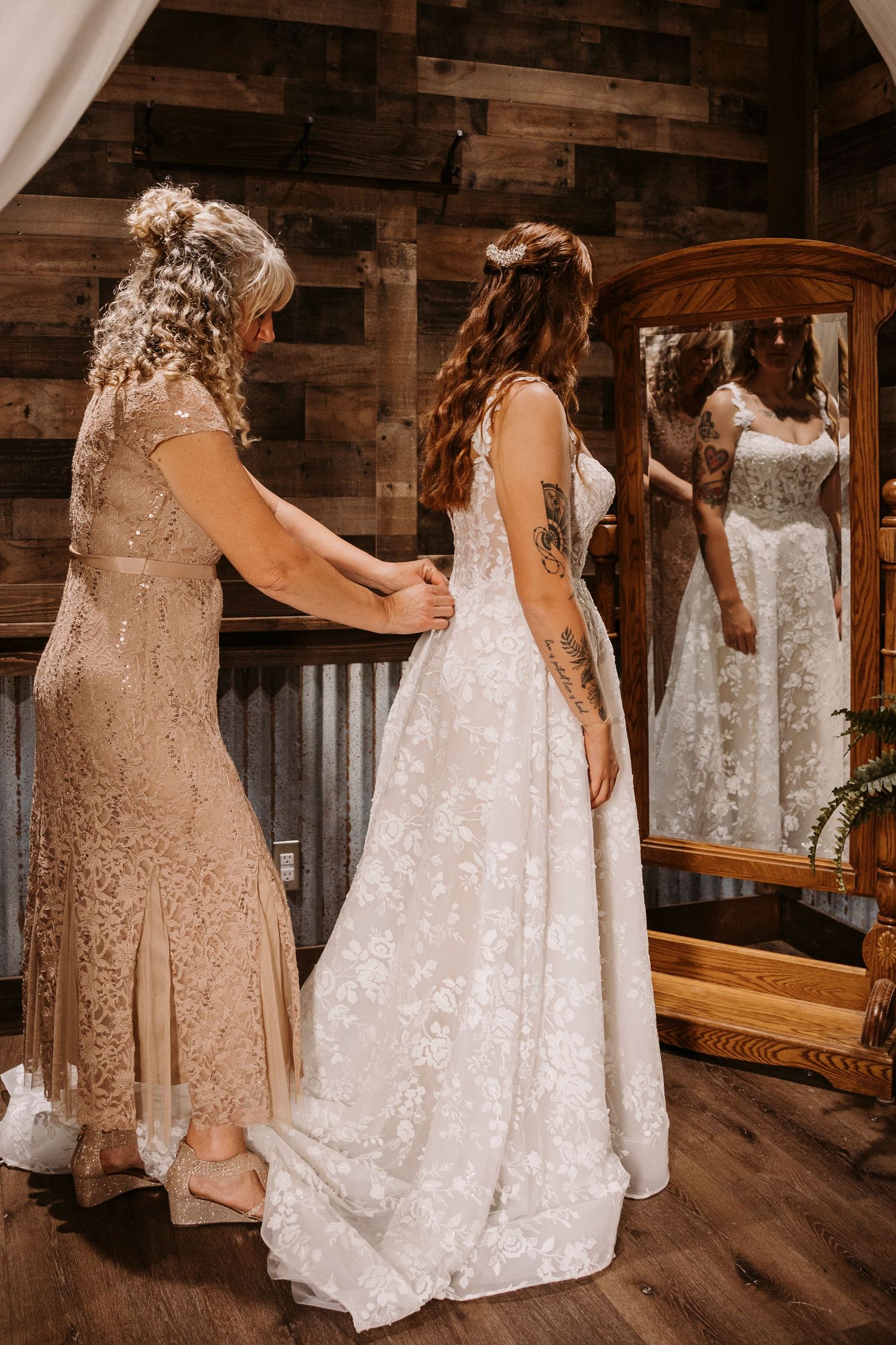 Elegant wedding dresses in white and champagne colors displayed in a rustic wooden venue.