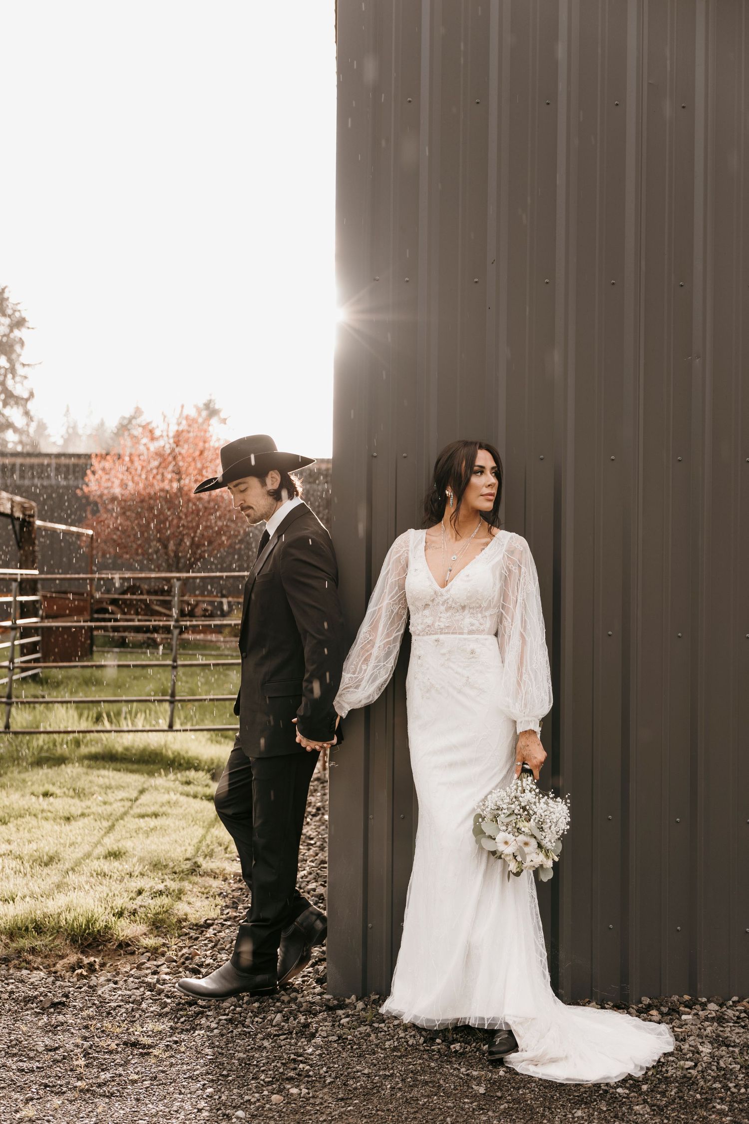 Artistic wedding photos against a dark barn wall with dramatic lighting.