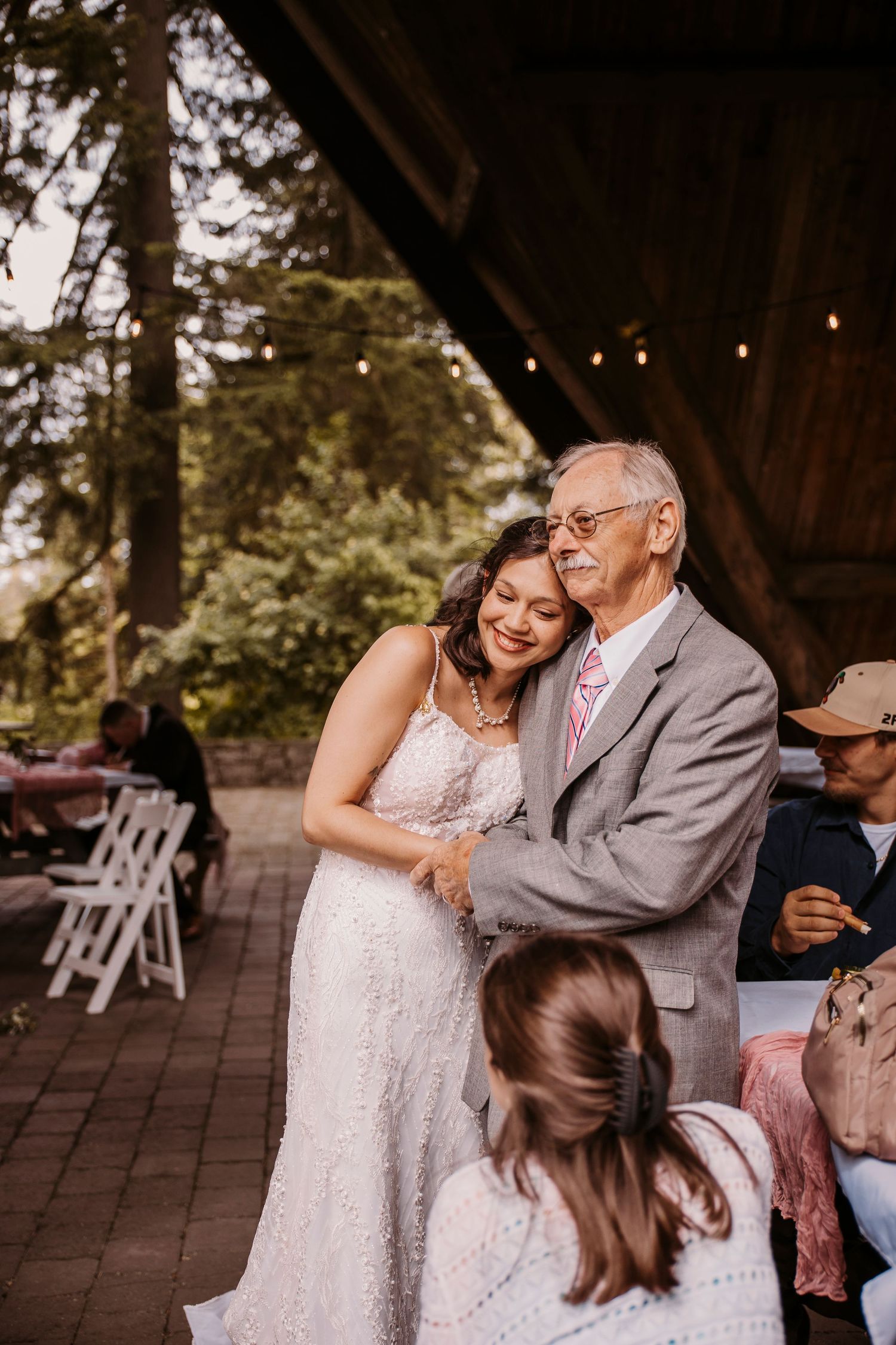 A joyful dance moment at a wedding reception under string lights.