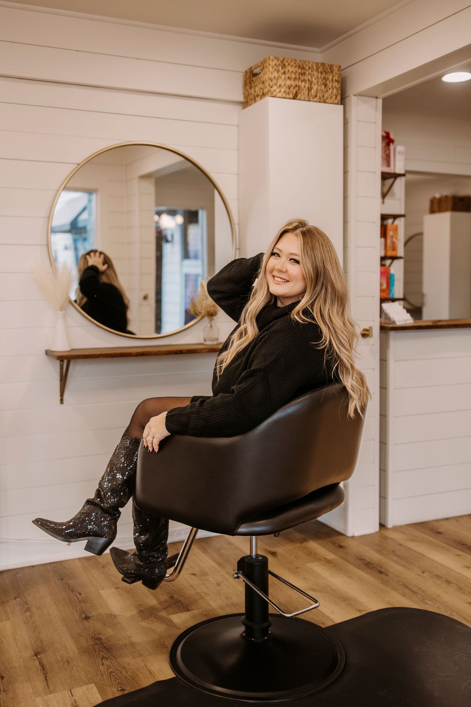 Salon chair setup in modern space with white shiplap walls and wooden flooring.