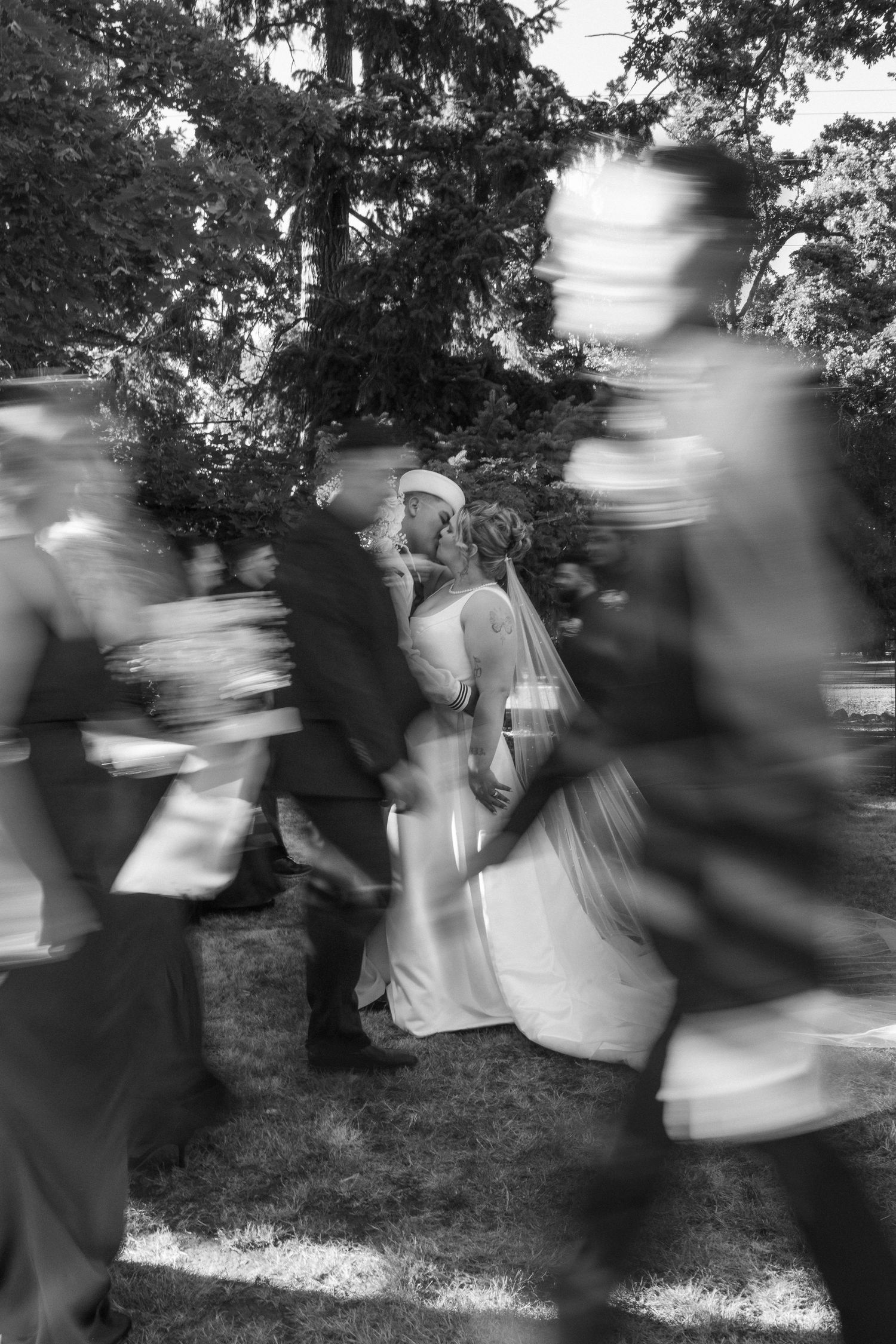 An artistic black and white photo captures motion blur around a couple during their wedding ceremony.