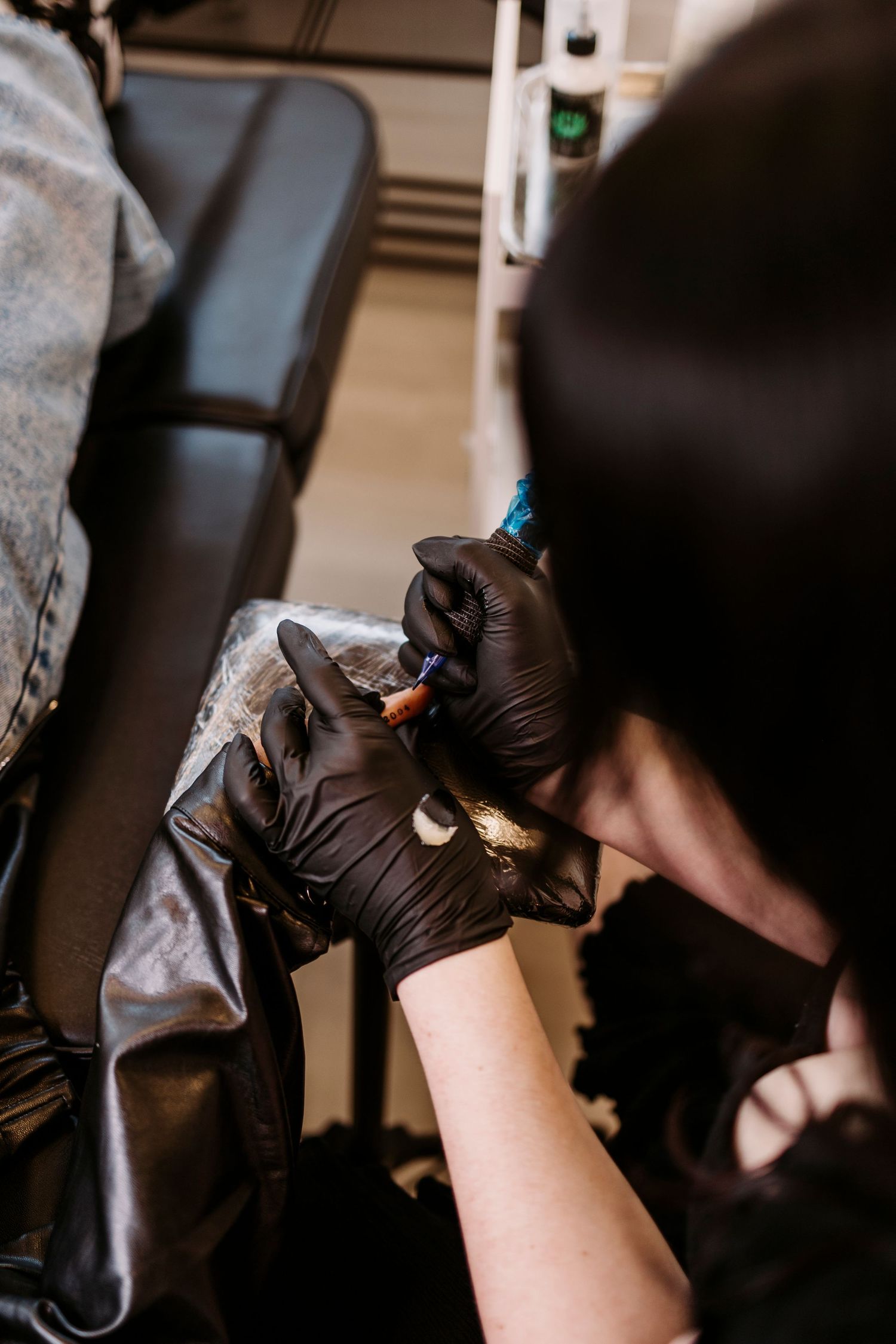 Detailed view of hands wearing black gloves performing precise lash application.