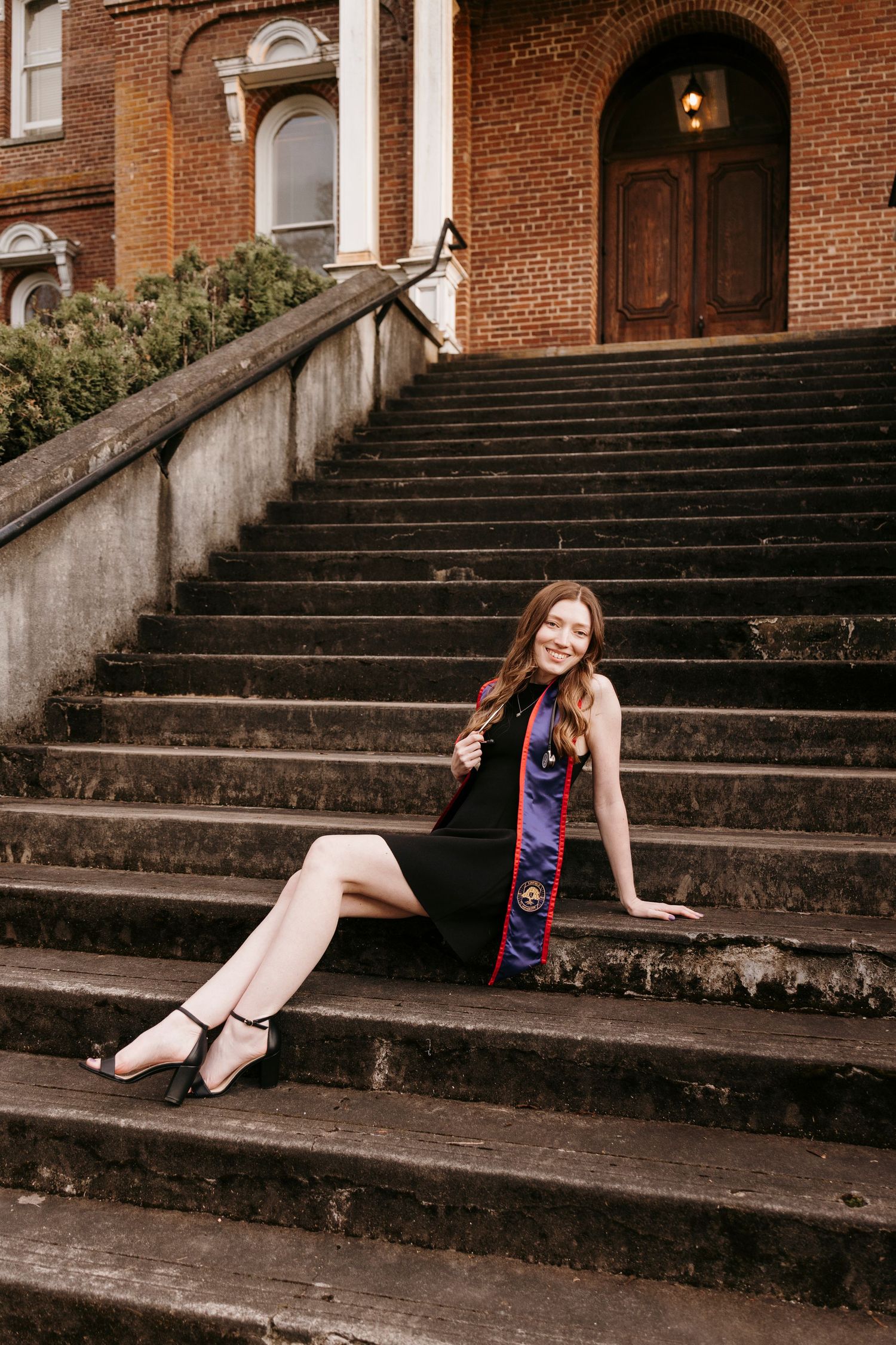 Artistic graduation photo series on historic brick building steps.