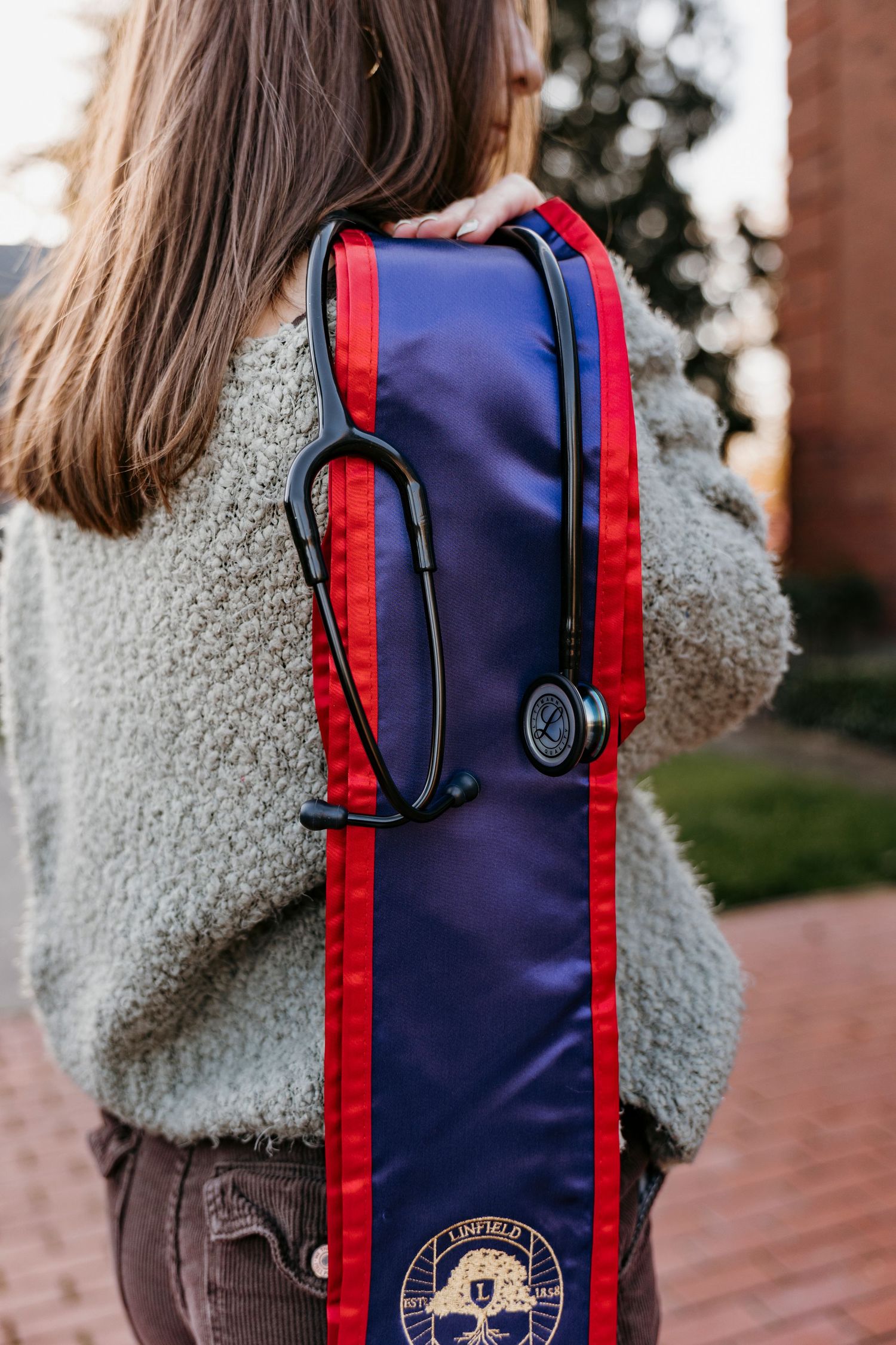 Navy blue backpack with red trim and university logo detail.