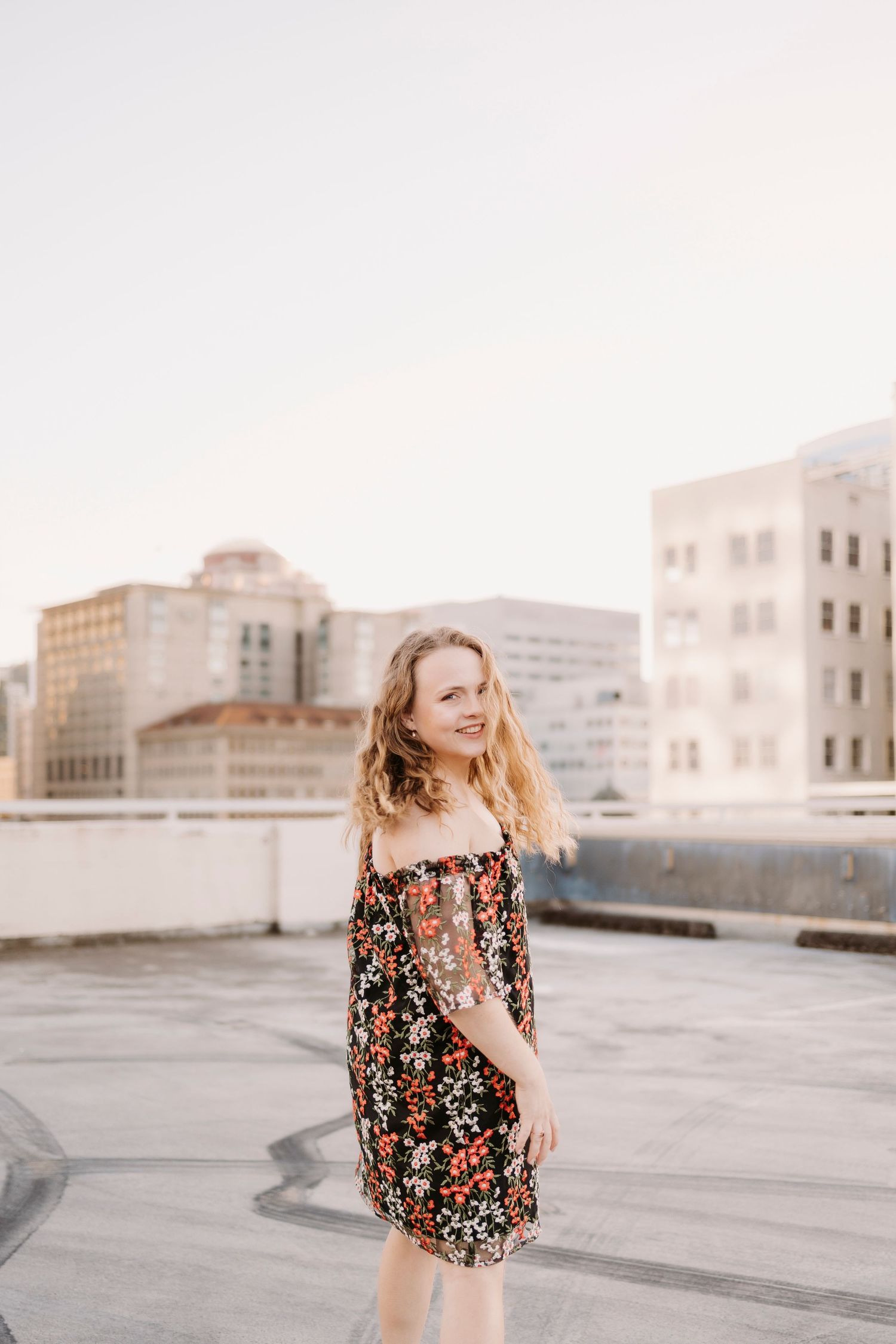 Rooftop photoshoot with city buildings in background during golden hour.
